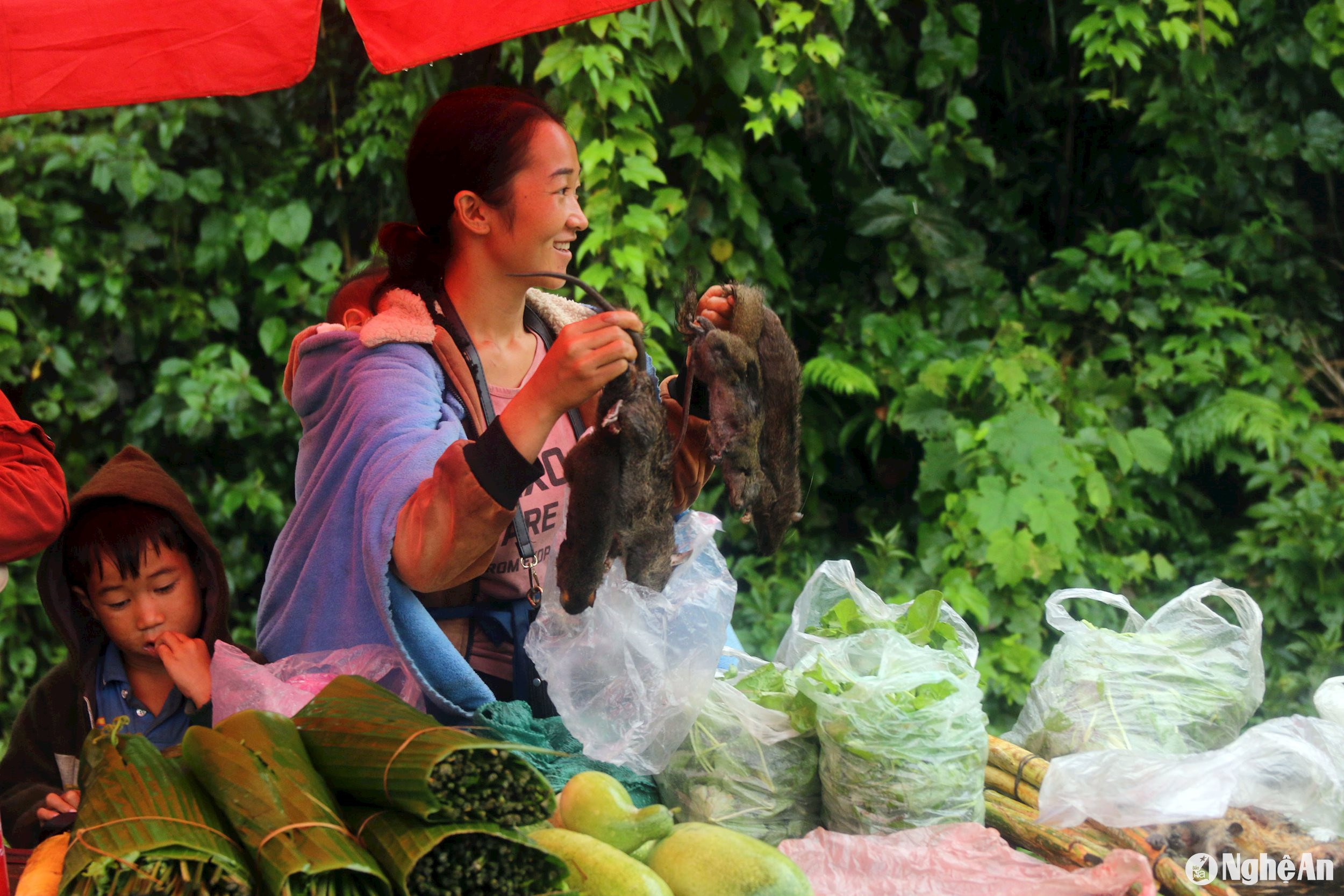 Một phụ nữ người Lào đang quảng cáo những con chuột rừng để thu hút người mua.