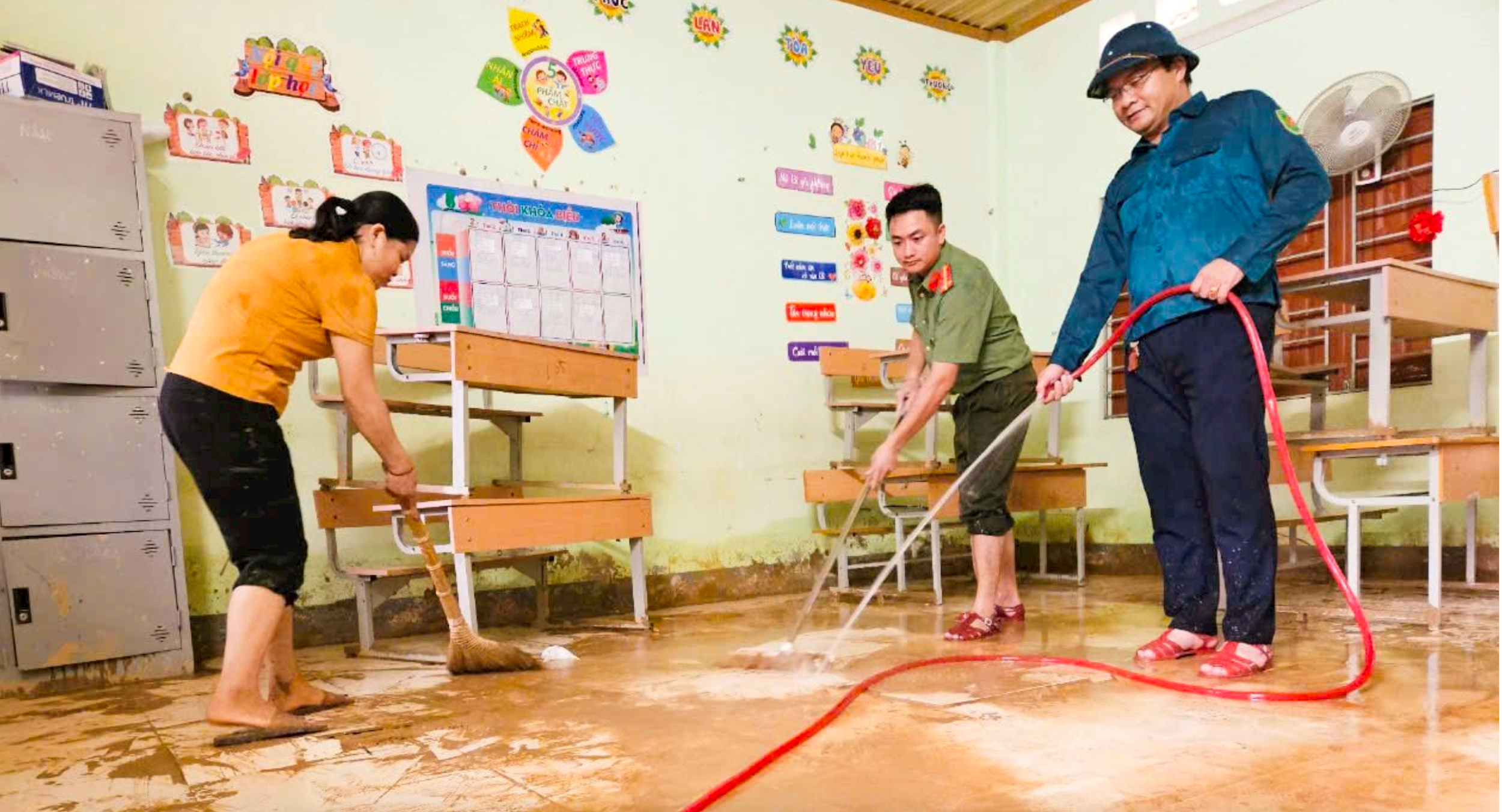 Cán bộ UBND huyện tương Dương và giáo viên Trường PTDTBT tiểu hcoj Lượng Minh dọn dẹp trường lớp. Ảnh: HT