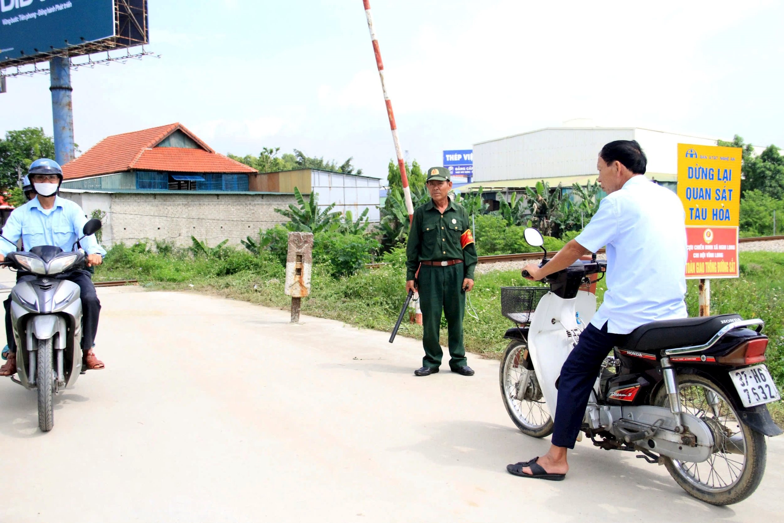 Cựu chiến binh xã Nghi Long (Nghi Lộc) thực hiện nhiệm vụ đảm bảo an toàn tại tuyến đường ngang giao với đường sắt. Ảnh: Công Kiên