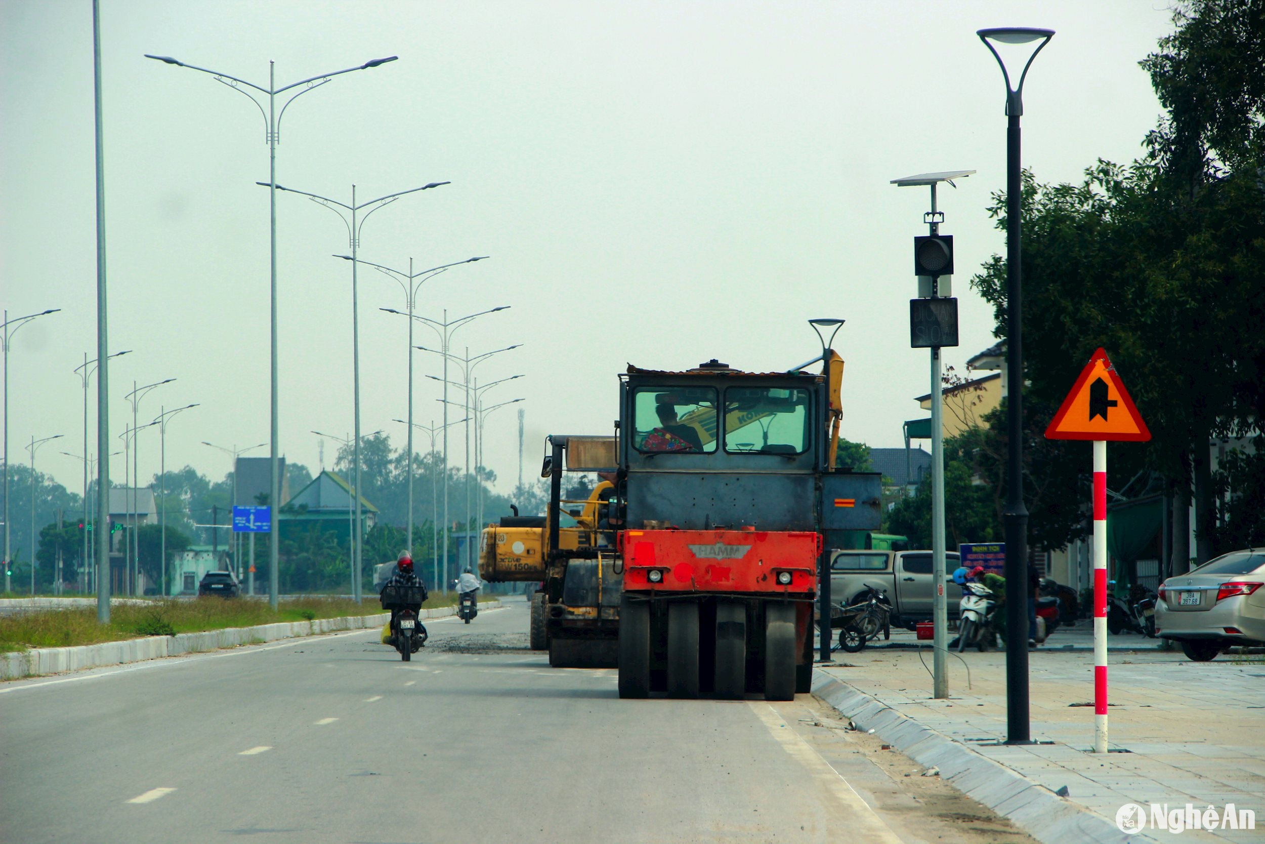 Máy móc tiếp tục thi công hoàn thiện các hạng mục trên tuyến Đại lộ Vinh - Cửa Lò. Ảnh: Quang An