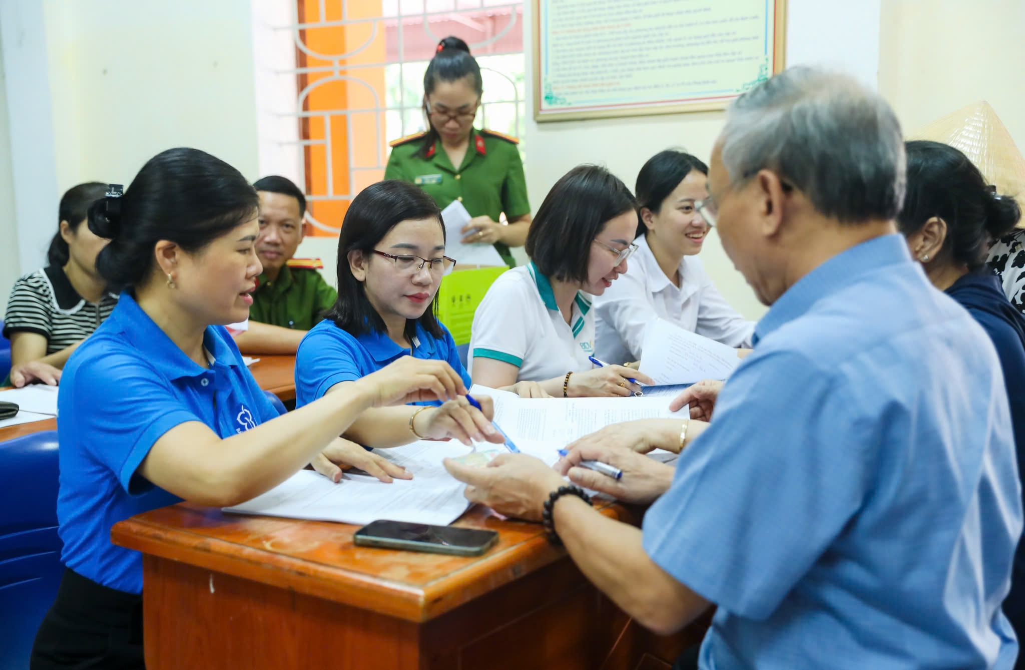 Cơ quan BHXH phối hợp các ngành liên quan hướng dẫn người dân nhận lương hưu qua tài khoản cá nhân. Ảnh Đức Anh