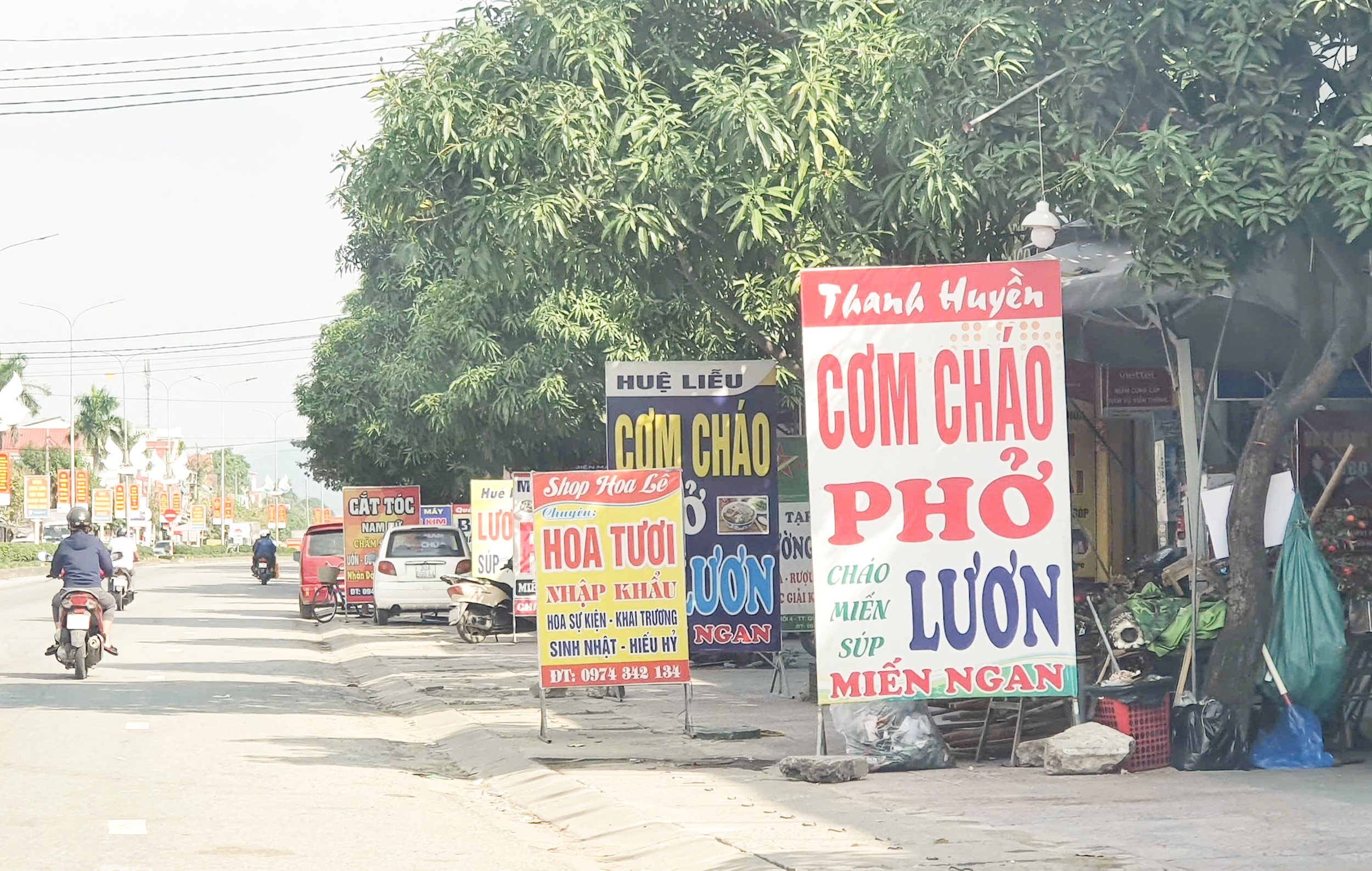 Những tấm biển hiệu dựng lấn chiếm vỉa hè ở thị trấn Quán Hành (Nghi Lộc)