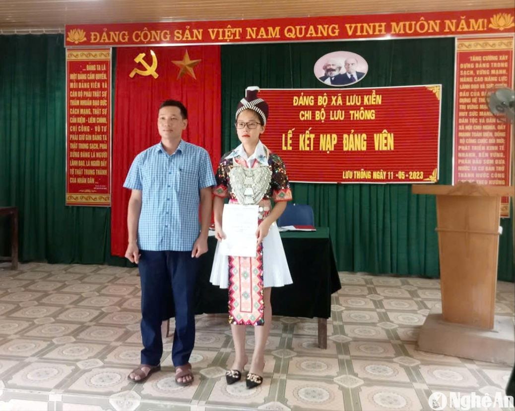 Đảng viên trẻ người Mông Vừ Thu Trang chụp ảnh với Phó Bí thư trực Đảng xã Lưu Kiền Lữ Văn Hải tại lễ kết nạp đảng viên. Ảnh: CSCC