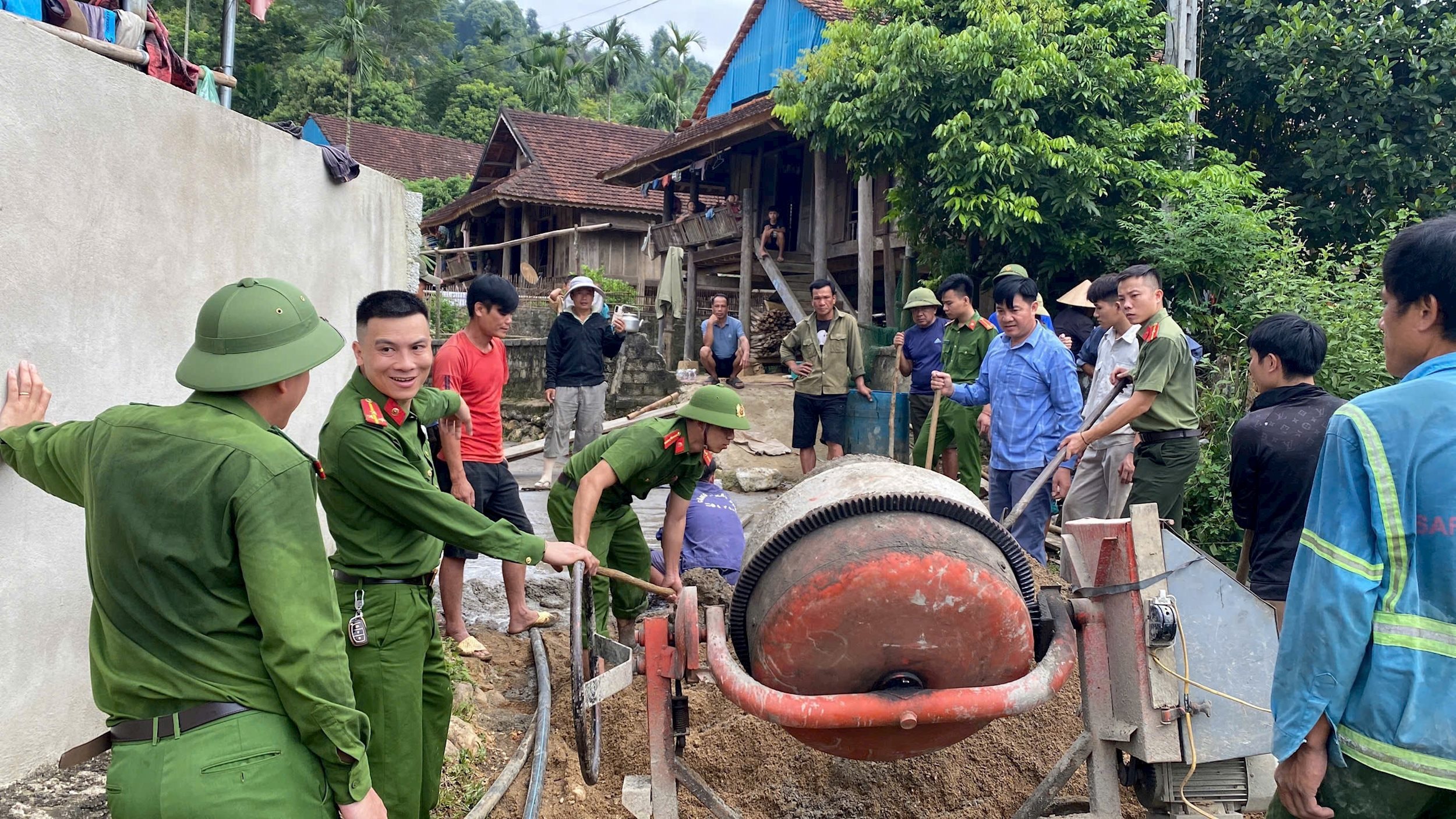 Lực lượng công an và các ban, ngành, đoàn thể xã Châu phong hỗ trợ người dân bản Lầu làm đường giao thông.