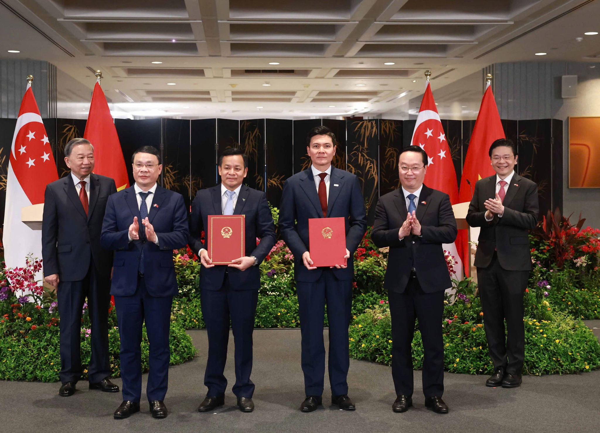 Dưới sự chứng kiến của Tổng Bí thư Tô Lâm và Thủ tướng Singapore Lawrence Wong, Bí thư Tỉnh ủy Nguyễn Đức Trung trao quyết định chấp thuận chủ trương đầu tư Dự án VSIP Nghệ An 3 cho lãnh đạo Tập đoàn Sembcorp và VSIP. Ảnh: Khánh Thục