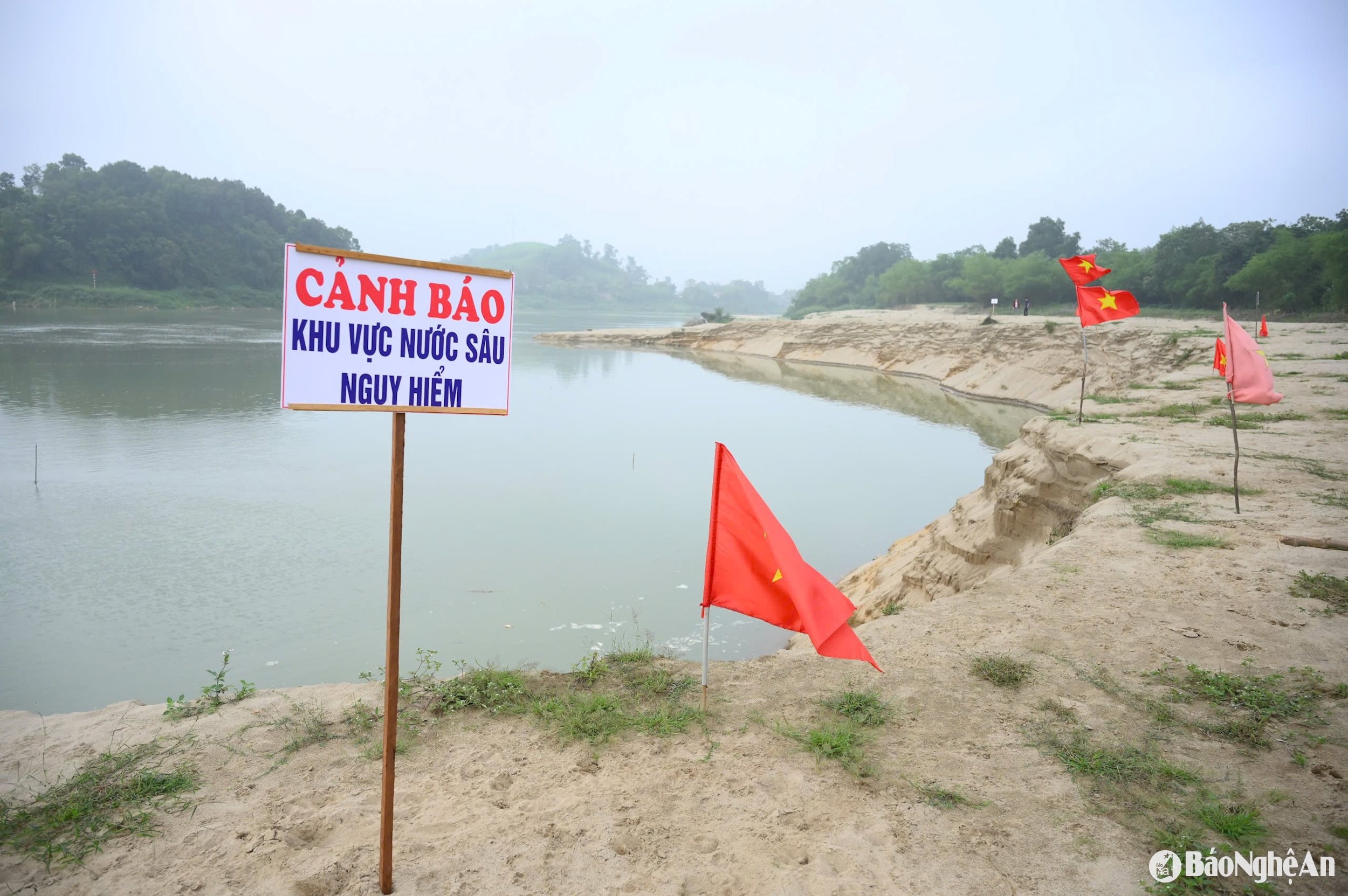 Khu vực sạt lở do tình trạng khai thác cát không tuân thủ quy định, người dân cắm cờ và đặt biển cảnh báo nguy hiểm. Ảnh: Thành Cường