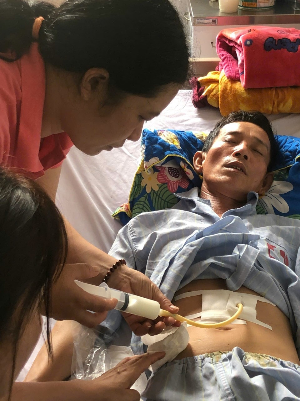លោកស្រី Truong Thi Chung ថែទាំលោក Ngo Xuan Tuyen នៅមន្ទីរពេទ្យ។ រូបថត៖ Thu Huong