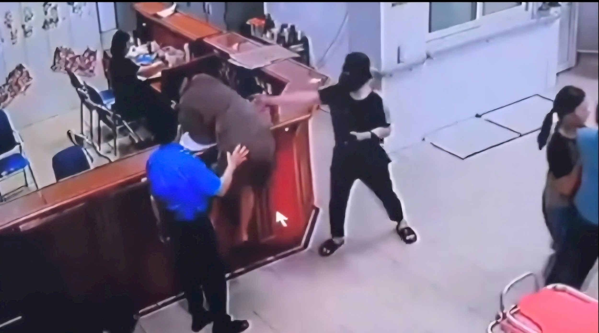 Un homme saute sur le comptoir d'enregistrement et agresse le personnel de l'hôpital, à côté de l'agent de sécurité de l'hôpital
