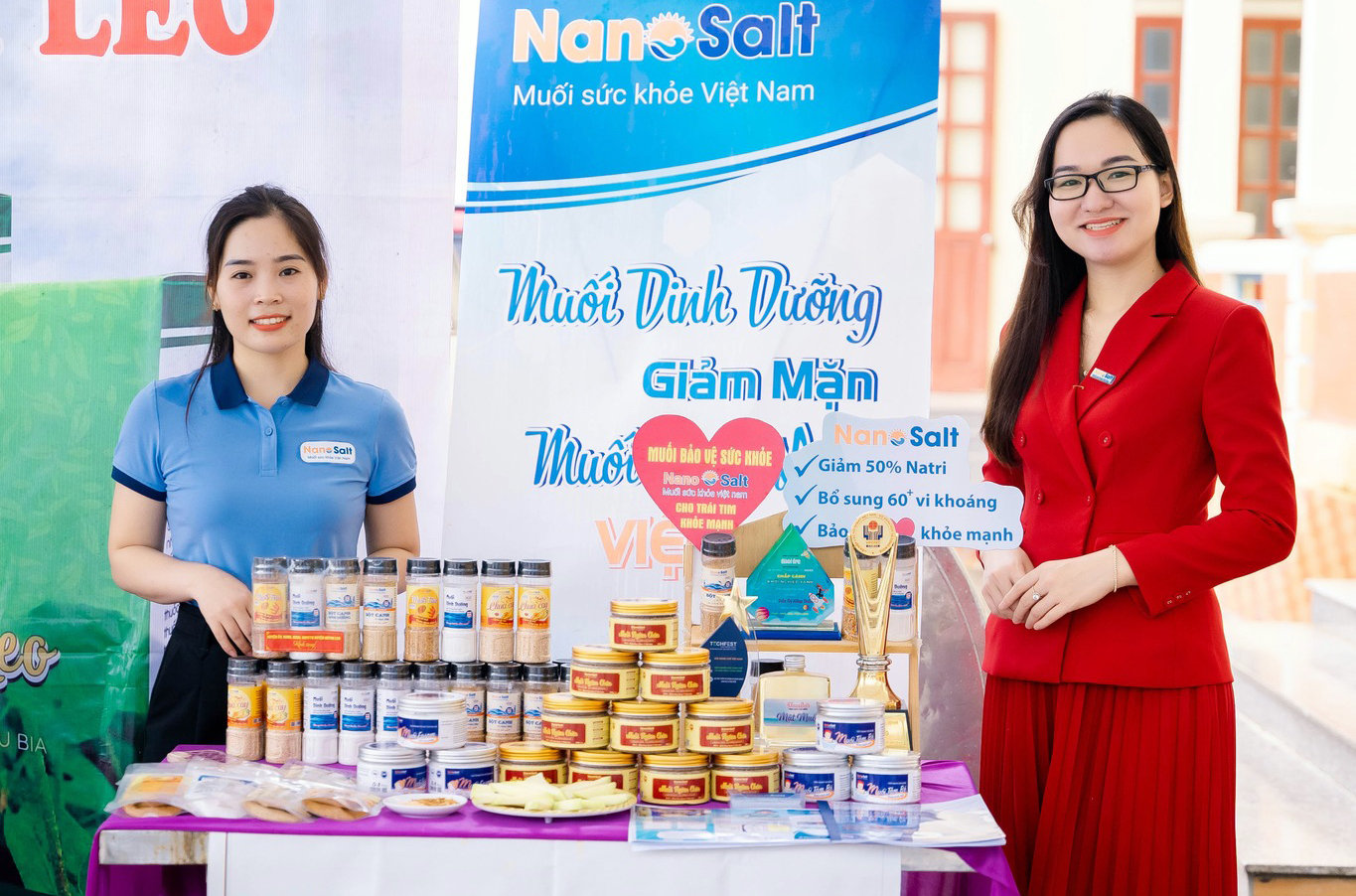 Chị Trần Thị Hồng Thắm (sinh năm 1993, bìa phải, xã Quỳnh Văn, huyện Quỳnh Lưu) bên các sản phẩm liên quan đến dòng muối giảm mặn NanoSalt được thị trường đón nhận sâu rộng trong thời gian qua. Ảnh: Thanh Quỳnh