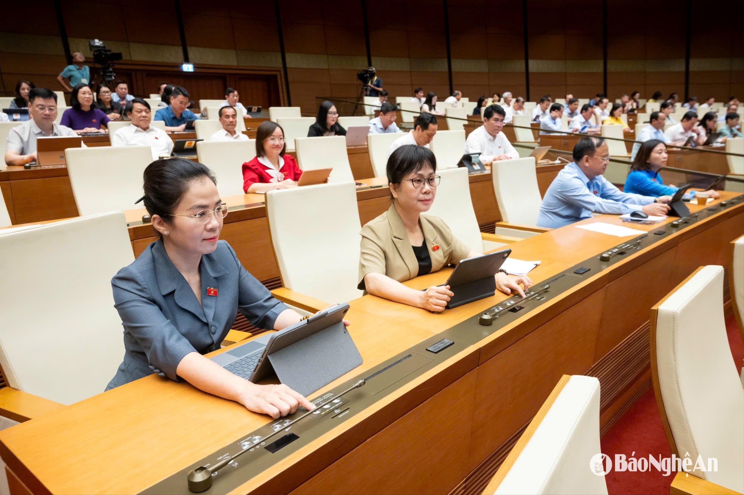 Đồng chí Võ Thị Minh Sinh - Phó Bí thư Tỉnh ủy, Chủ tịch Ủy ban MTTQ Việt Nam tỉnh, Trưởng đoàn ĐBQH tỉnh Nghệ An và các ĐBQH bấm nút biểu quyết. Ảnh: Nam An