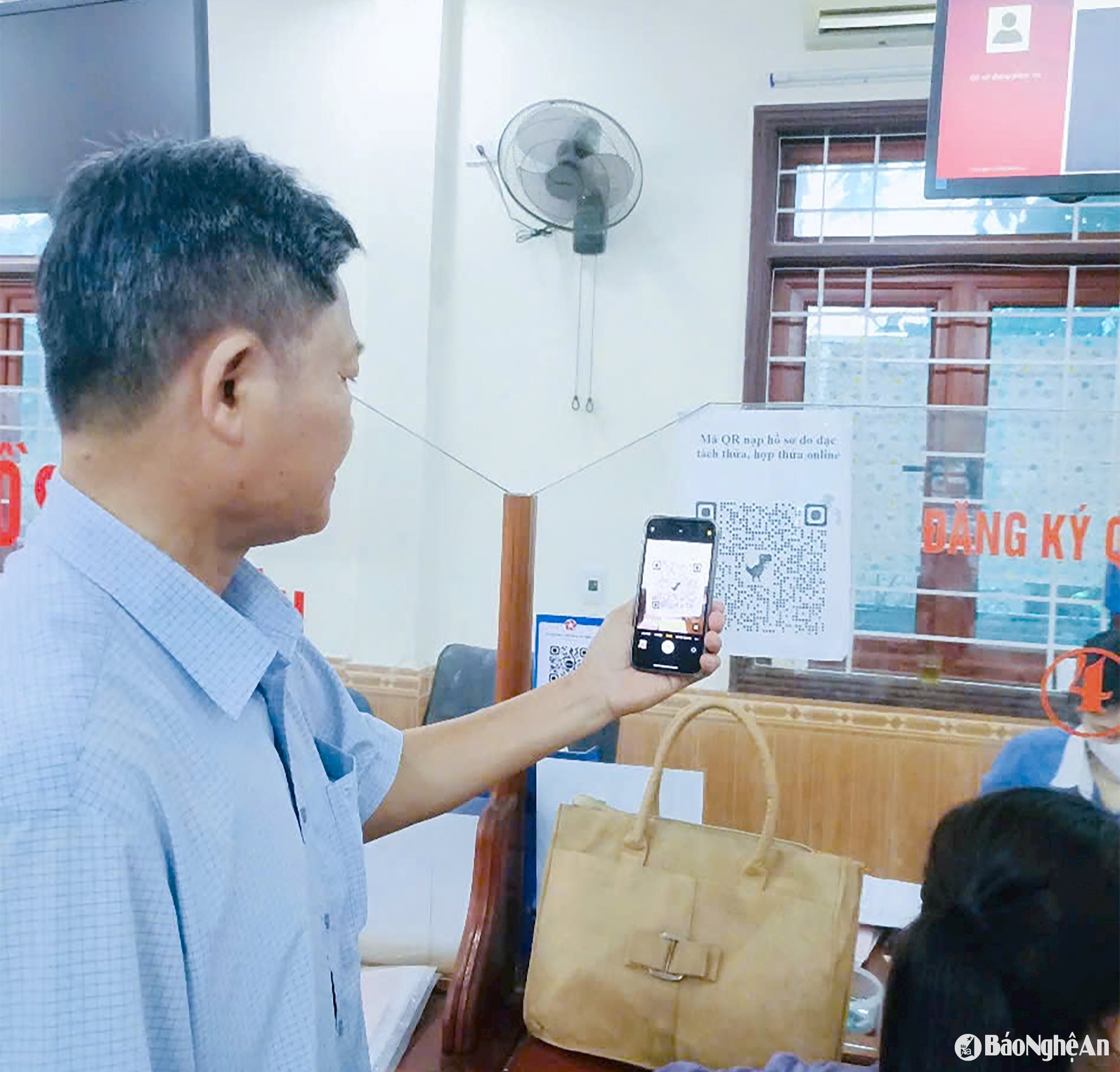 Người dân huyện Nghi Lộc quét mã QR tra cứu quy trình giải quyết thủ tục hành chính về đất đai tại bộ phận %22một cửa%22 huyện. Ảnh Mai Hoa