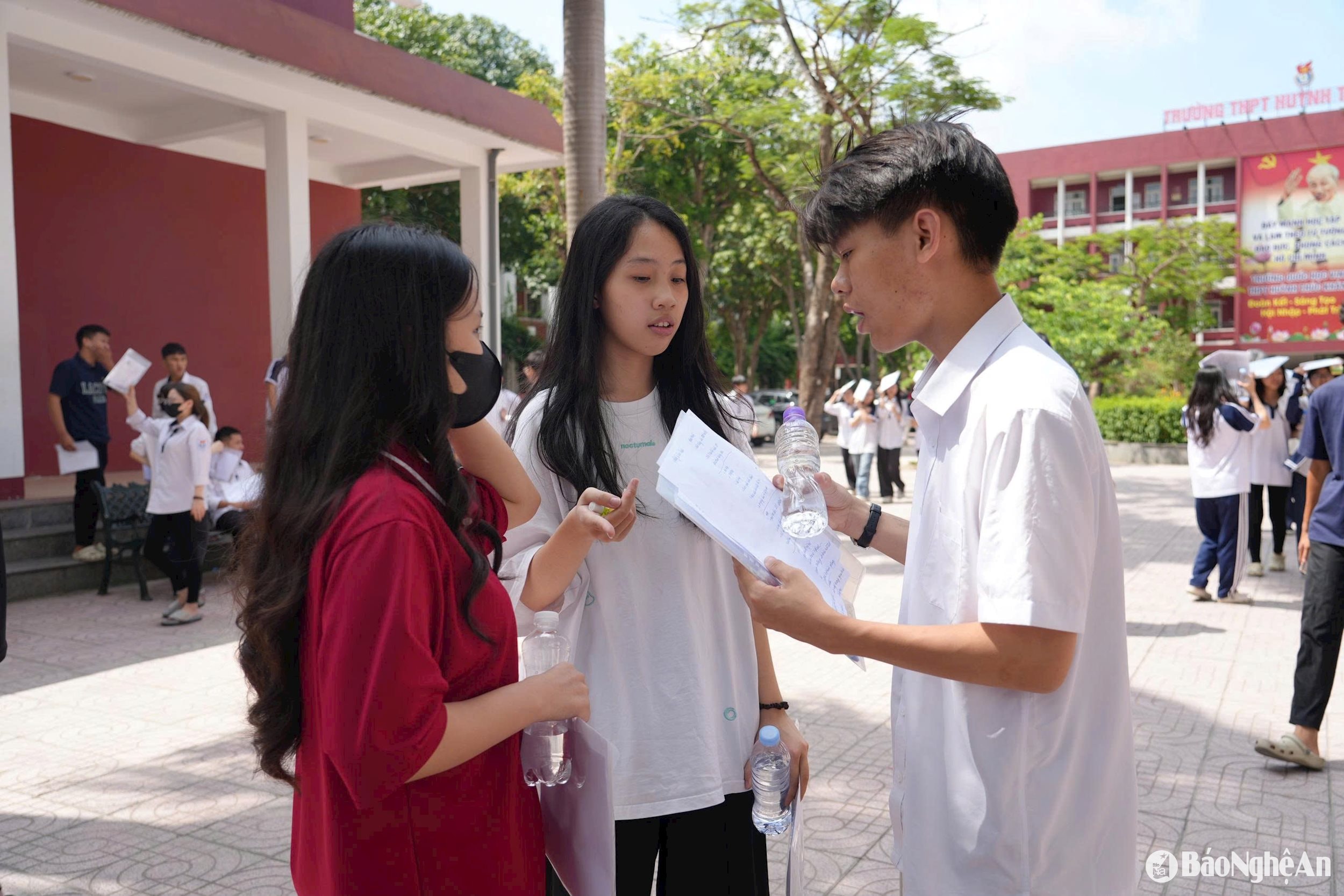 Thí sinh tại điểm thi Trường THPT Huỳnh Thúc Kháng trao đổi bài sau khi thi xong môn Ngữ văn. Ảnh - Đức Anh