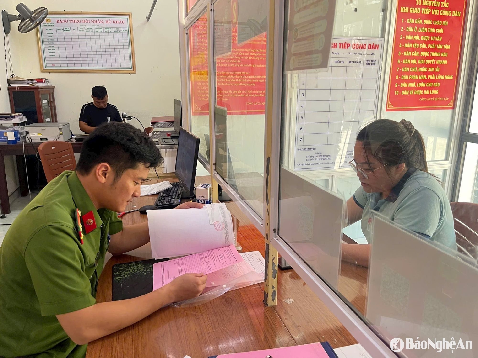 Thượng úy Trần Văn Long xử lý hồ sơ cho người dân.