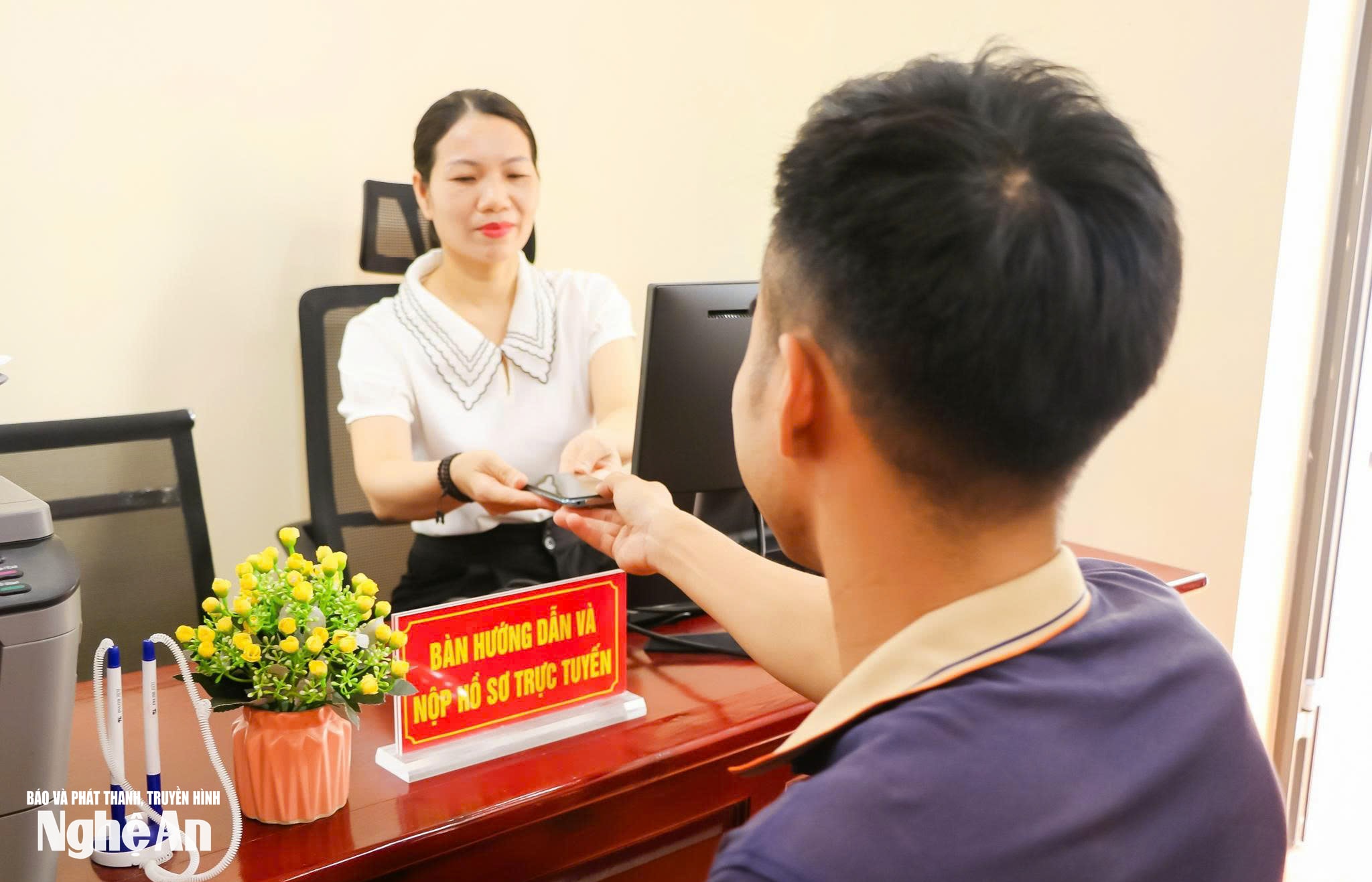 Cán bộ phường Vinh Hưng hướng dẫn tổ chức, cá nhân giải quyết thủ tục hành chính bằng hình thức trực tuyến