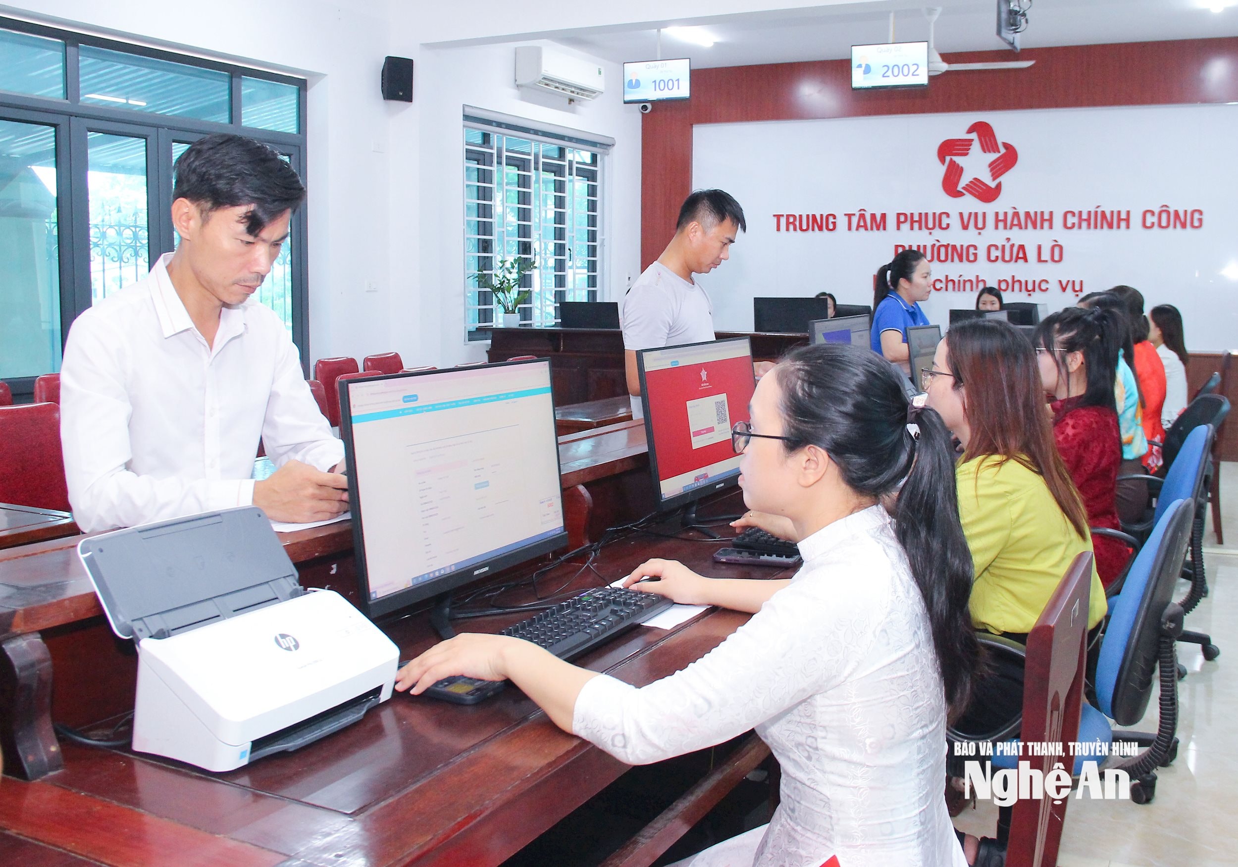  Cán bộ Trung tâm Phục vụ hành chính công phường Cửa Lò giải quyết thủ tục cho người dân. Ảnh Mai Hoa