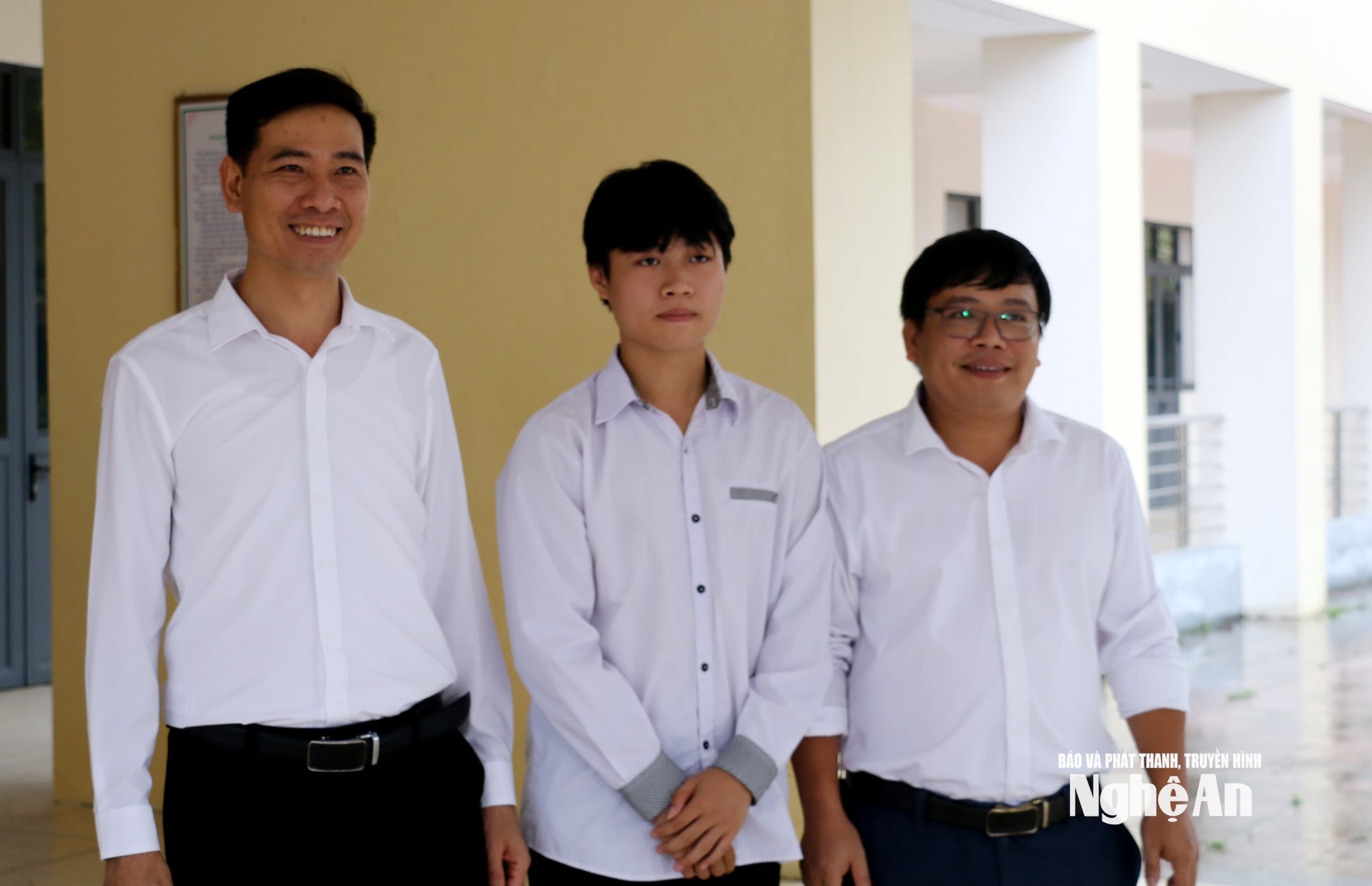 Hiệu trưởng Trường THPT Kim Liên (trái) chúc mừng thành tích của thầy giáo chủ nhiệm và học sinh Phạm Nhật Long. Ảnh - Mỹ Hà
