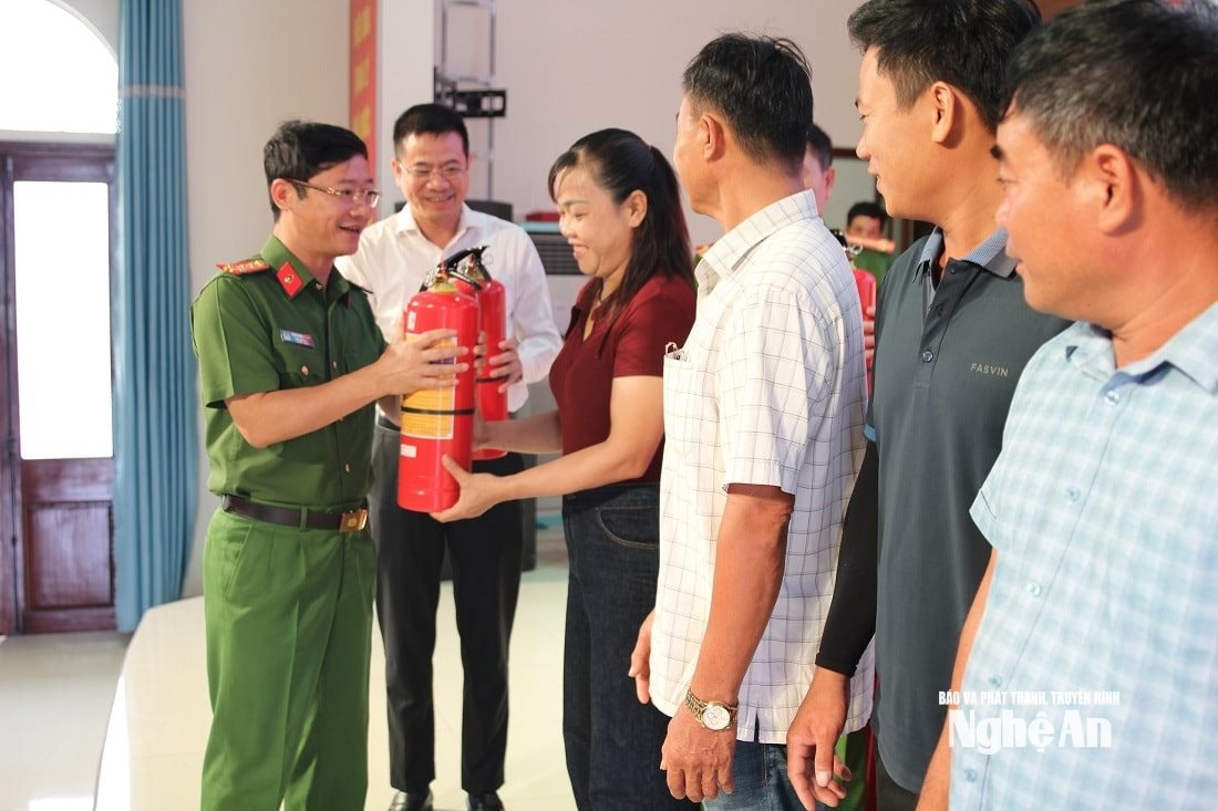Đại tá Trần Ngọc Tuấn, Phó Giám đốc Công an tỉnh trao bình chữa cháy cho người dân tại phường Tân Mai vào sáng 1/8. Ảnh: CANA