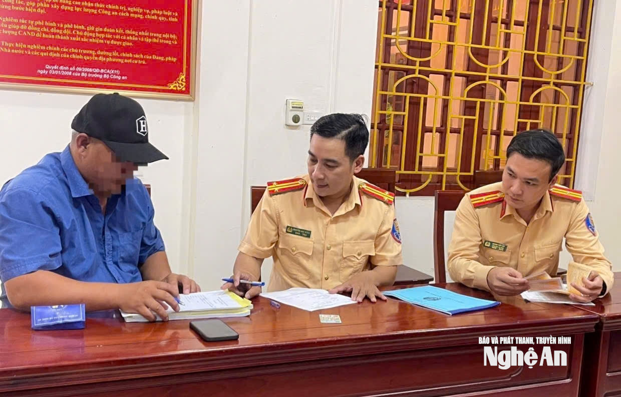 Cán bộ Đội CSGT đường bộ số 5, Phòng CSGT Công an tỉnh lập biên bản lái xe vi phạm. Ảnh Đ