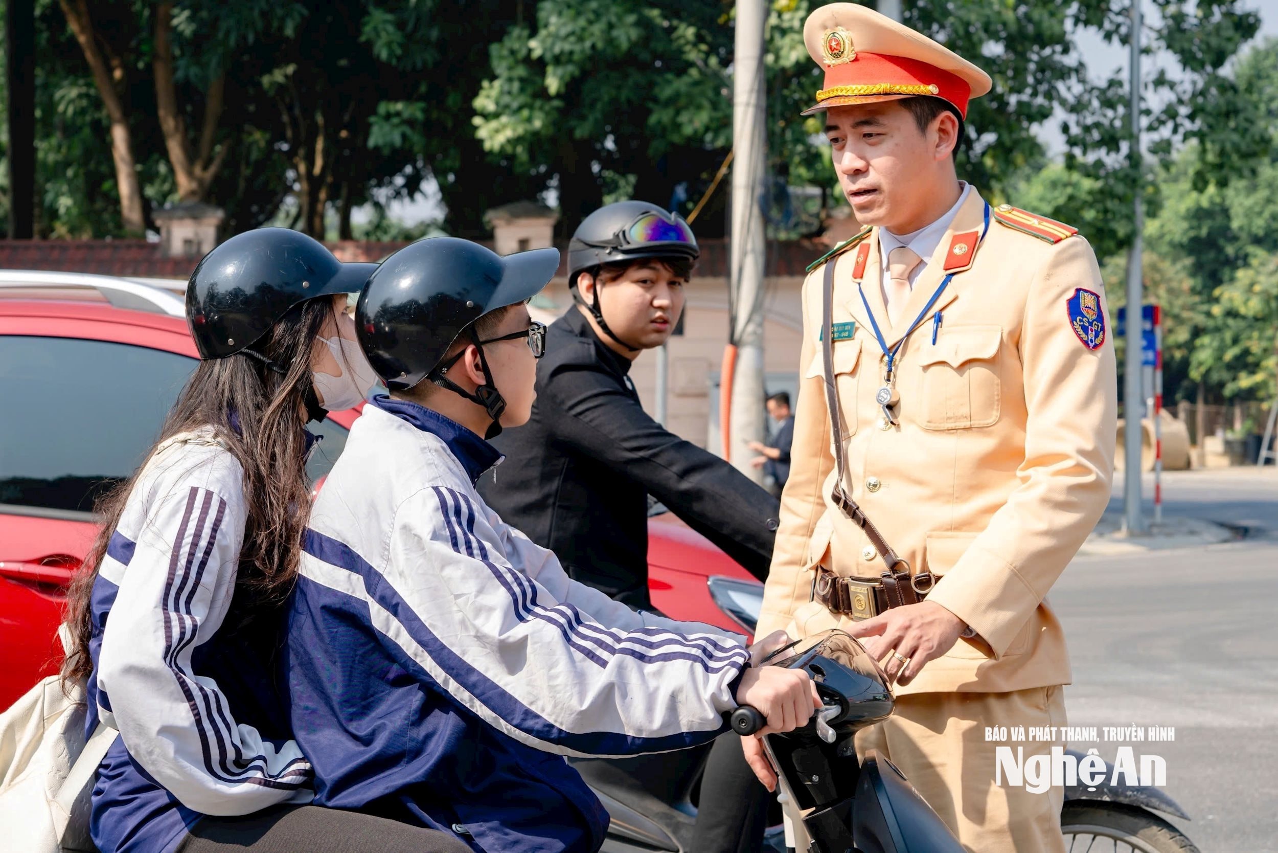 Cán bộ Tổ CSGT địa bàn Vinh nhắc nhở các em học sinh tham gia giao thông đảm bảo an toàn. Ảnh Nguyễn Đạo