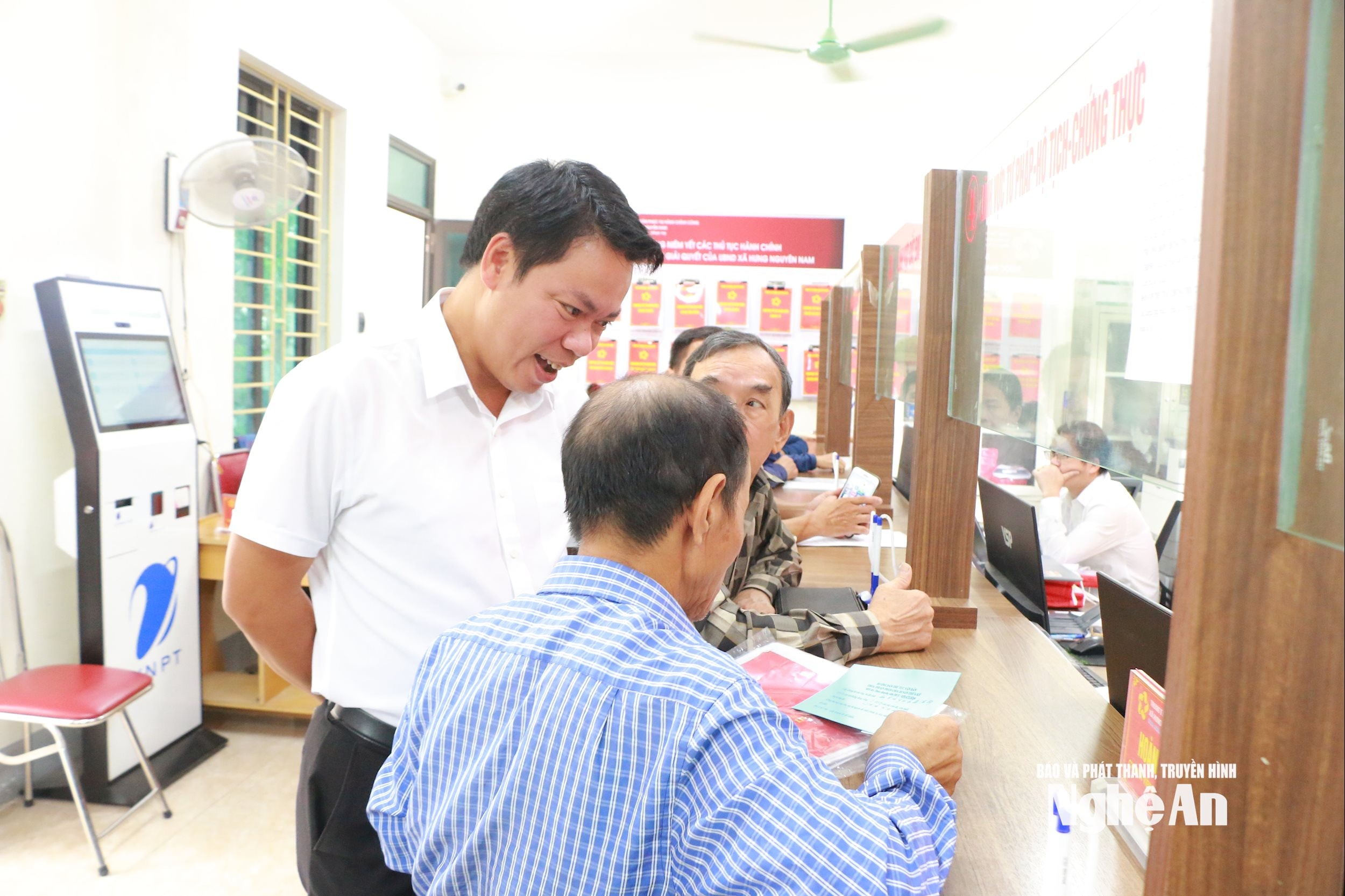Chủ tịch UBND xã Hưng Nguyên Nam Cao Anh Đức trao đổi với người dân tại Trung tâm Dịch vụ hành chính công của xã. Ảnh Khánh Ly