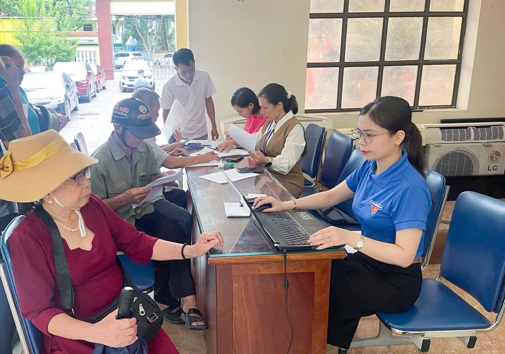 Cán bộ, công chức phường Vinh Lộc hỗ trợ người dân làm thủ tục hành chính