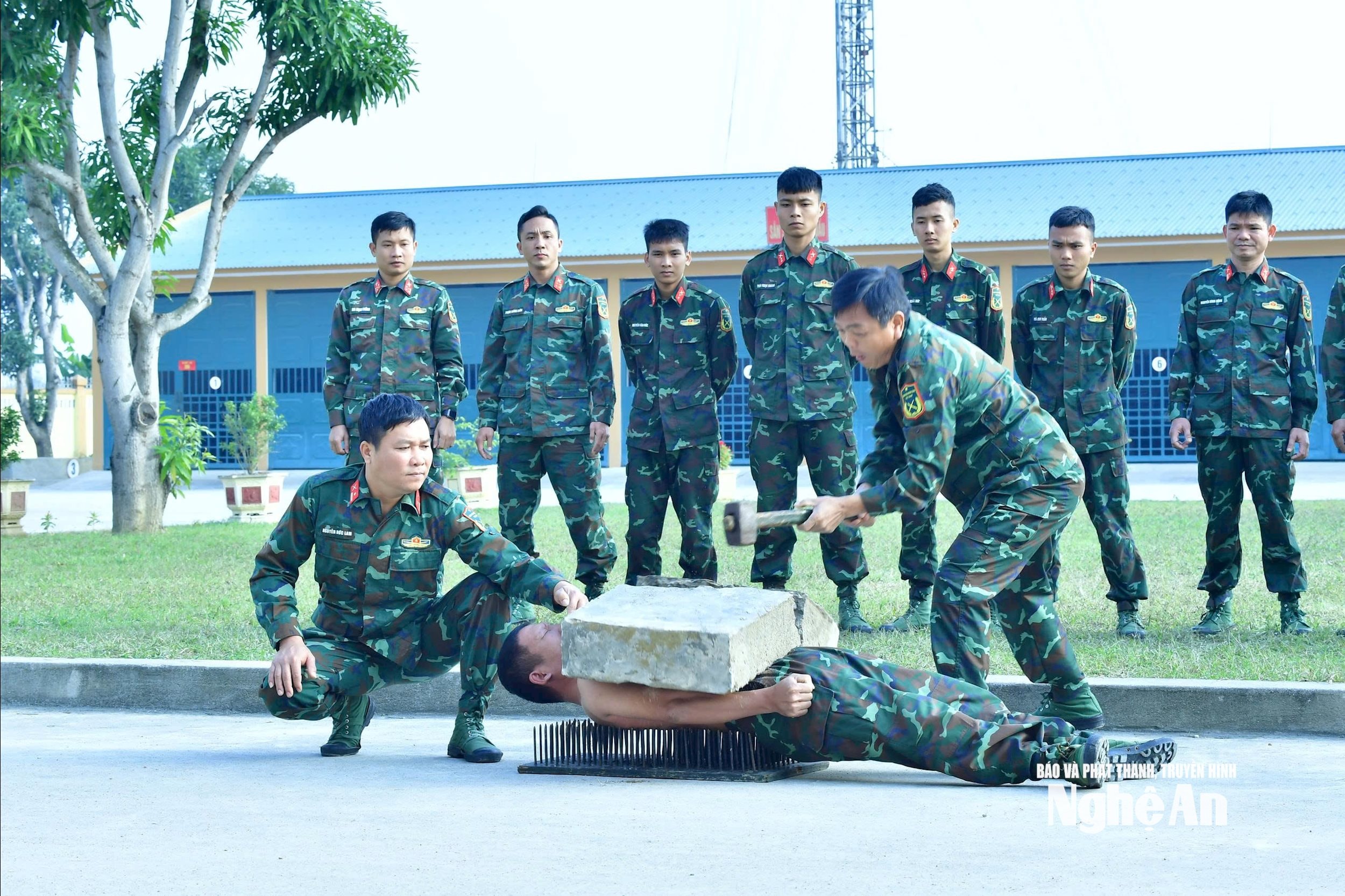 Người lính trinh sát với thân thể cứng như thép, nằm trên bàn chông làm 'giá đỡ' đập vỡ tảng đá. Ảnh Trọng Kiên