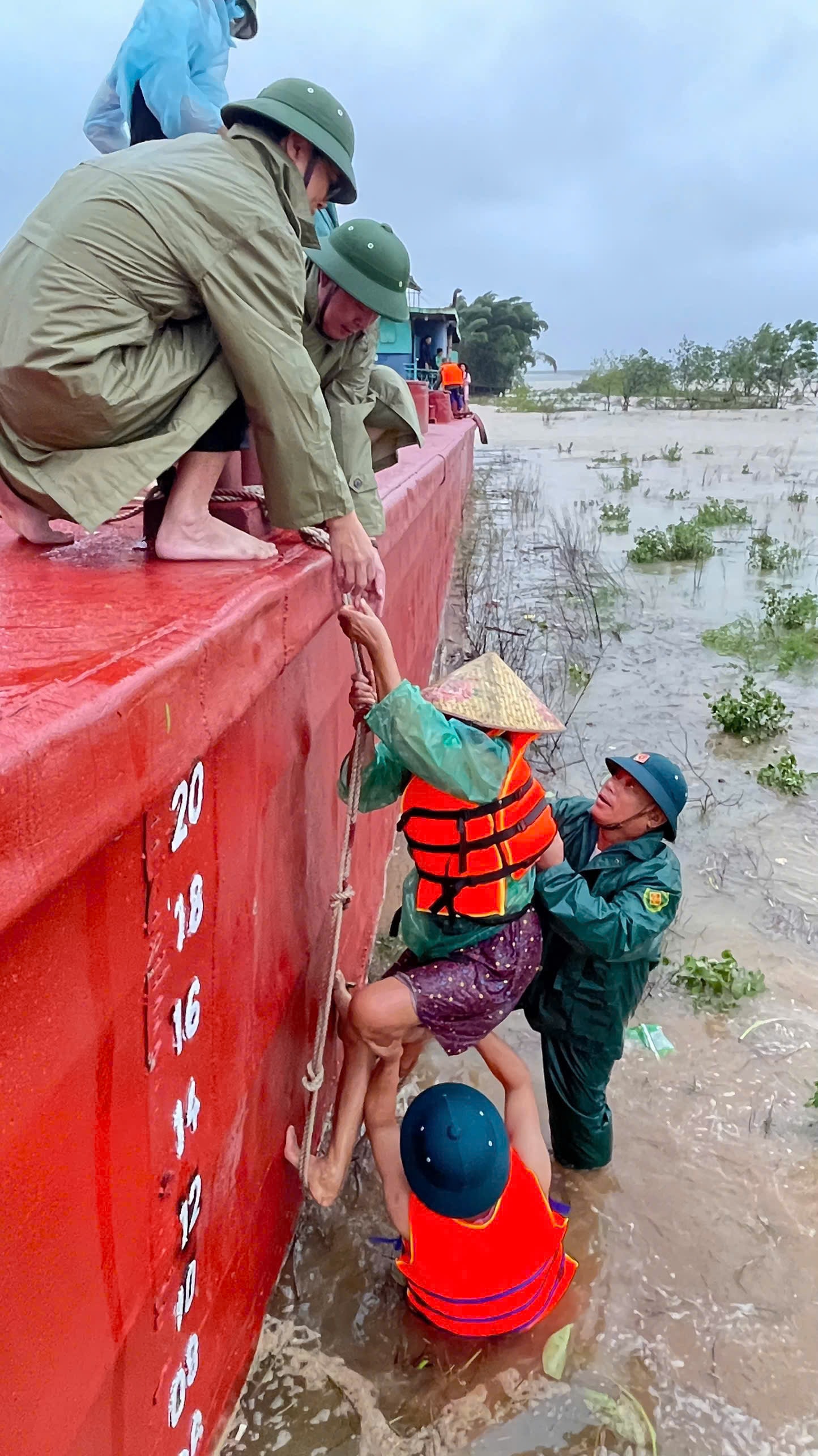  Lực lượng chức năng xã Lam Thành dùng xà lan ứng cứu 5 người dân bị mắc kẹt giữa sông Lam