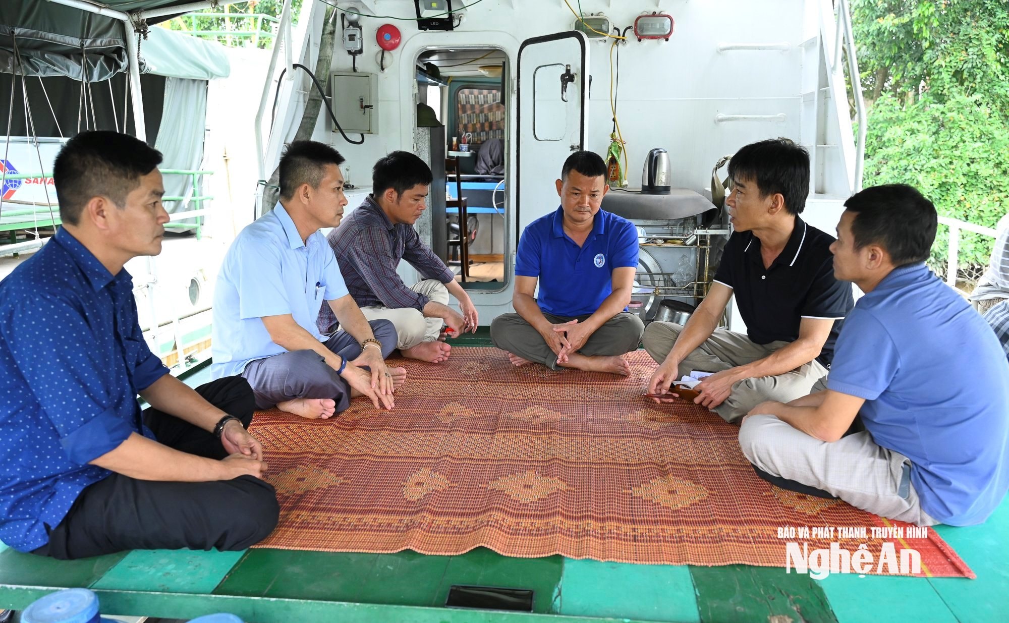 Nhà báo Nhật Lân trao đổi với nhân viên tàu kiểm ngư bị dừng hợp đồng về công tác vận hành tàu kiểm soát tàu cá đánh bắt thủy sản trên biển. Ảnh Thành Cường