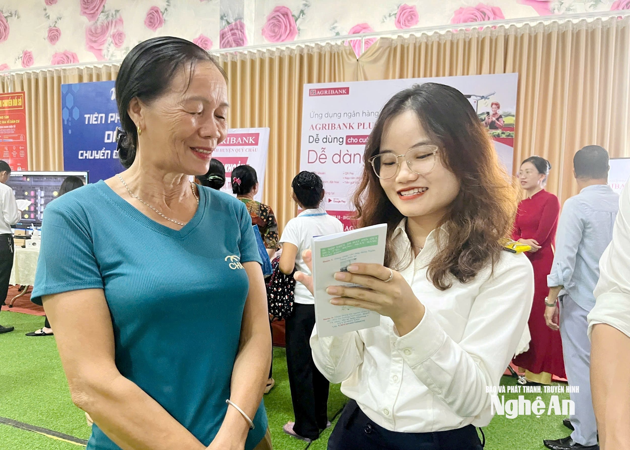 Người dân được cán bộ Chi cục thuế Phủ Quỳ I hướng dẫn sử dụng ứng dụng thuế. Ảnh Quang An