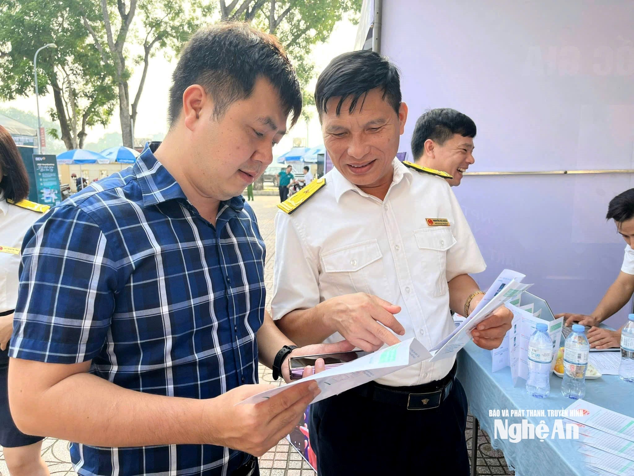 Người dân được cán bộ Chi cục Thuế Phủ Quỳ I hướng dẫn sử dụng ứng dụng thuế. Ảnh Quang An2