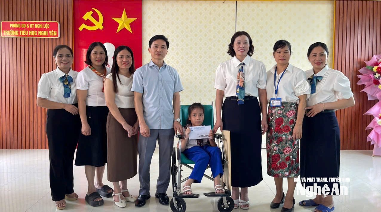 Ông Phan Sỹ Hiền (thứ 4 từ trái sang) cùng các nhà hảo tâm trao tặng học bổng dài hạn cho em Hoàng Thiên Trà, sinh năm 2016, tại xã Hải Lộc trước Trung thu. Ảnh: Thanh Quỳnh