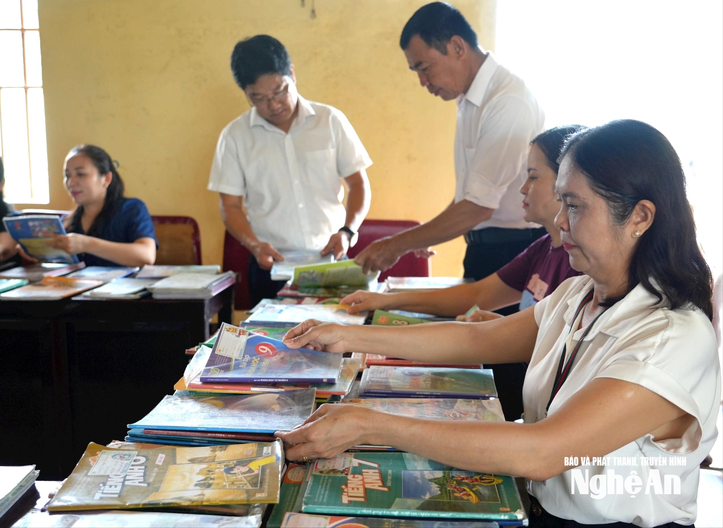Giáo viên Trường THCS Kỳ Tân sắp xếp lại những bộ sách giáo khoa cũ vừa được ủng hộ để trao tặng cho các học sinh bị thiệt hại. Ảnh: Mỹ Hà