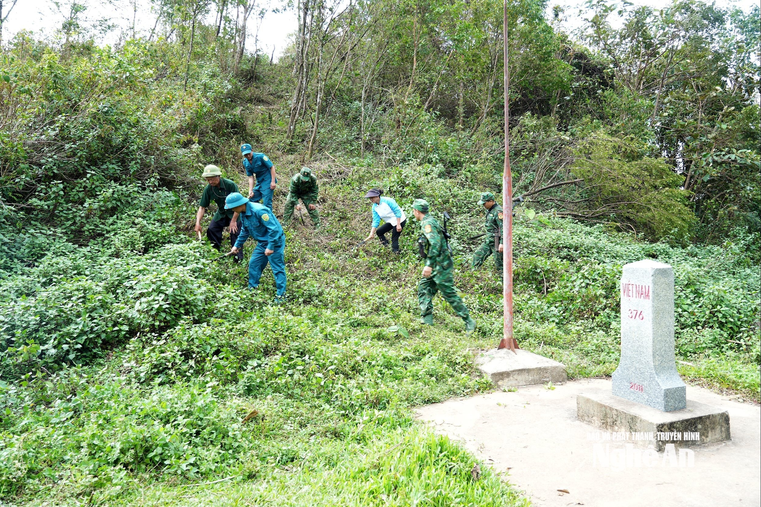 Nhân dân bản Huồi Mới cùng các chiến sĩ Đồn Biên phòng Tri Lễ dọn dẹp đường biên, cột mốc. Ảnh Tiến Đông