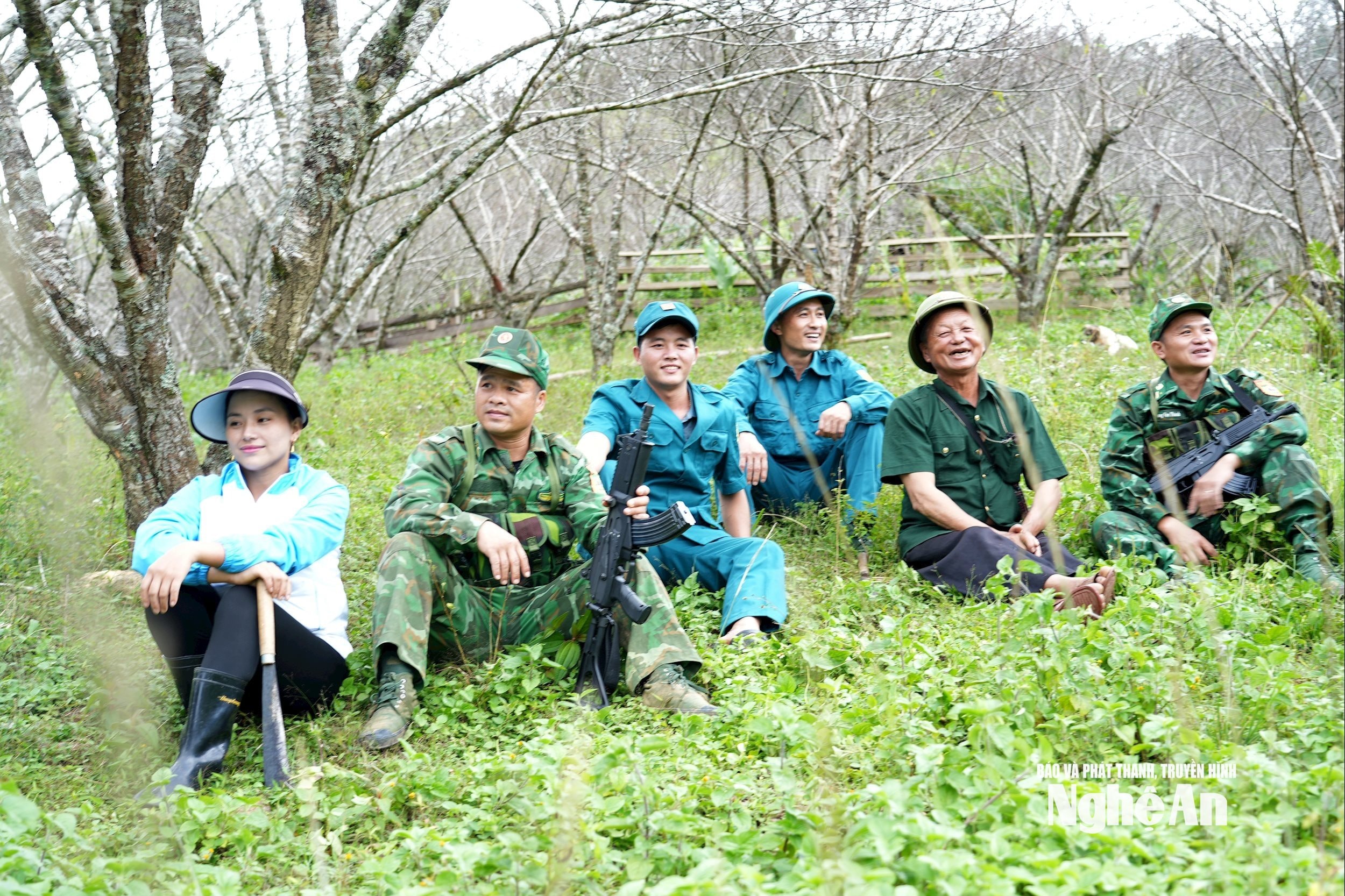 Thò Bá Của (thứ 3 từ trái qua), trong phút nghỉ ngơi khi cùng nhân dân trong bản đi dọn dẹp đường biên, cột mốc với các chiến sĩ Đồn Biên phòng Tri Lễ.