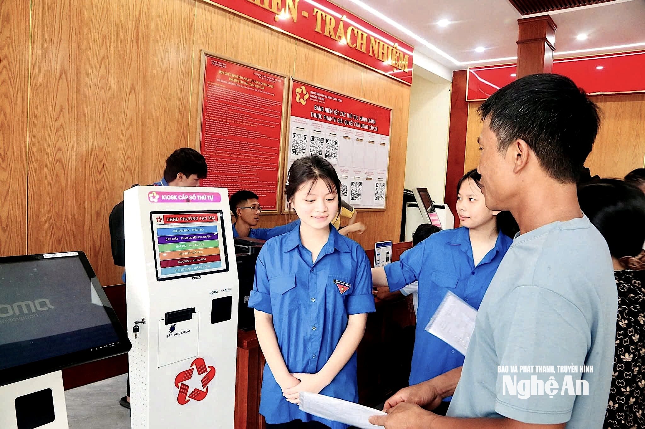 Lực lượng đoàn thanh niên hỗ trợ người dân làm thủ tục hành chính tại Trung tâm phục vụ hành chính công phường Tân Mai. Ảnh PV