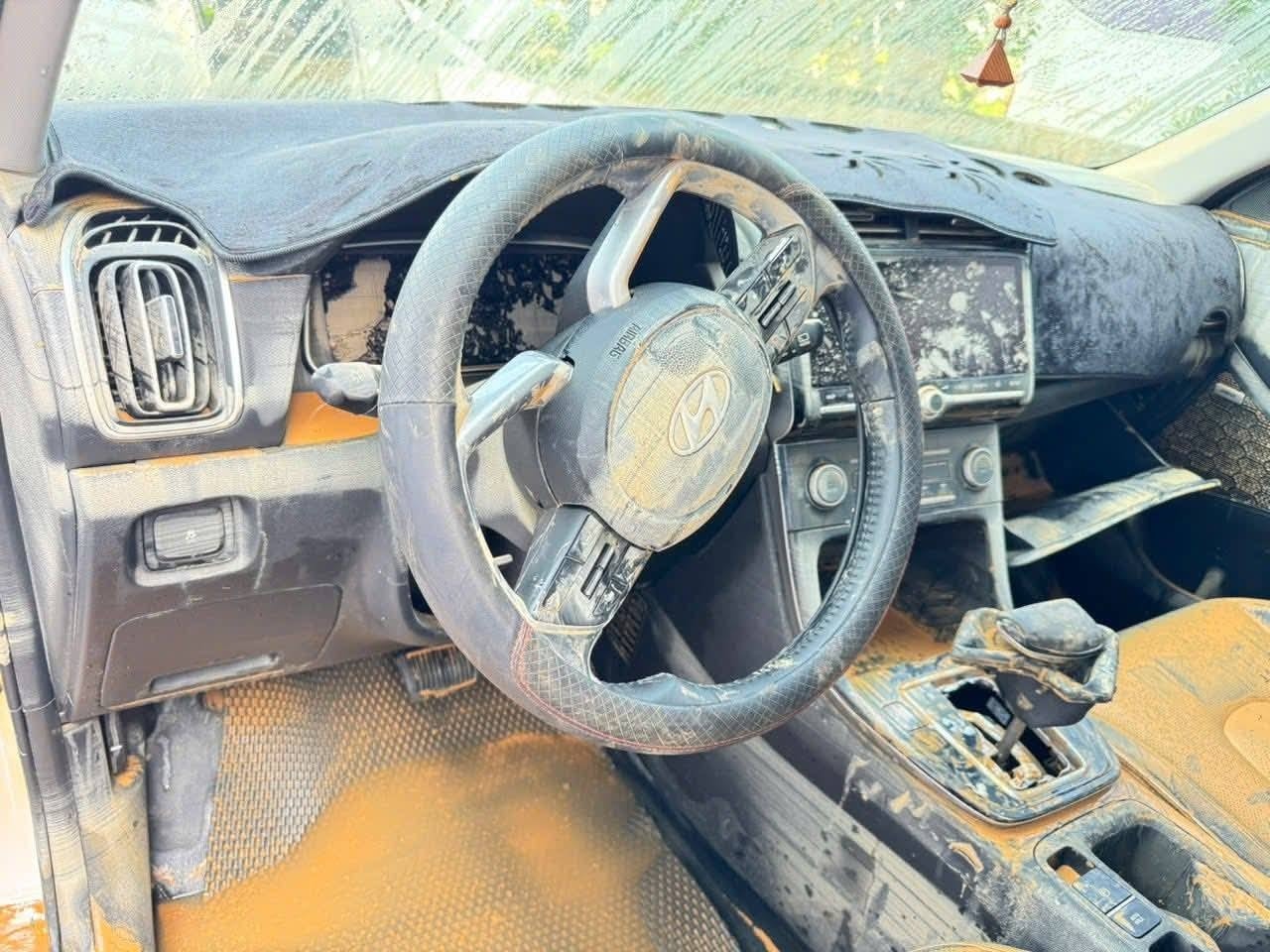 Một chiếc xe khác bị bùn đất bám đầy từ ngoại thất đến nội thất.