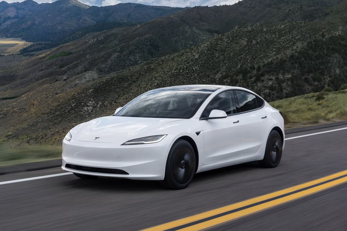 Ngoại thất xe điện Tesla Model 3 màu trắng đang di chuyển trên đường.