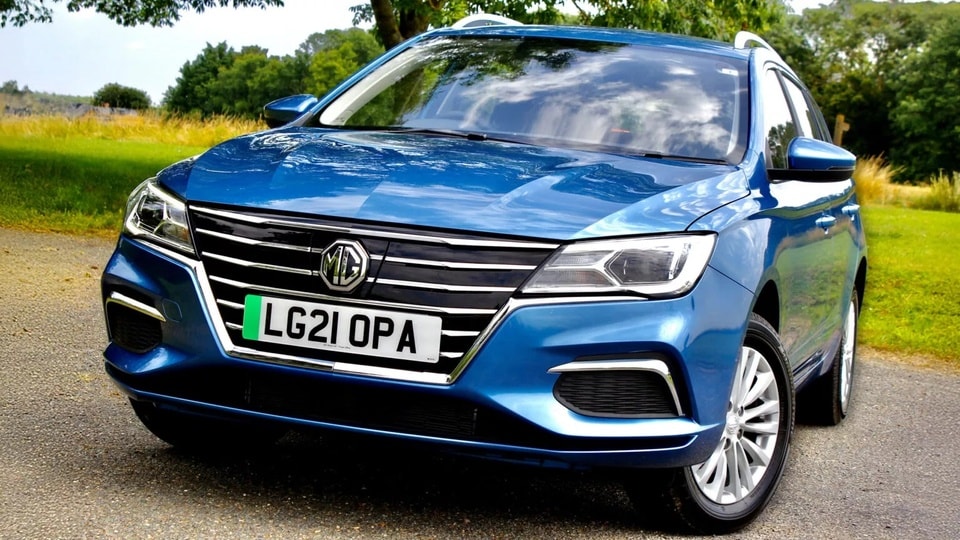 Chiếc xe điện MG5 EV màu xanh đang đỗ tại một trạm sạc công cộng.