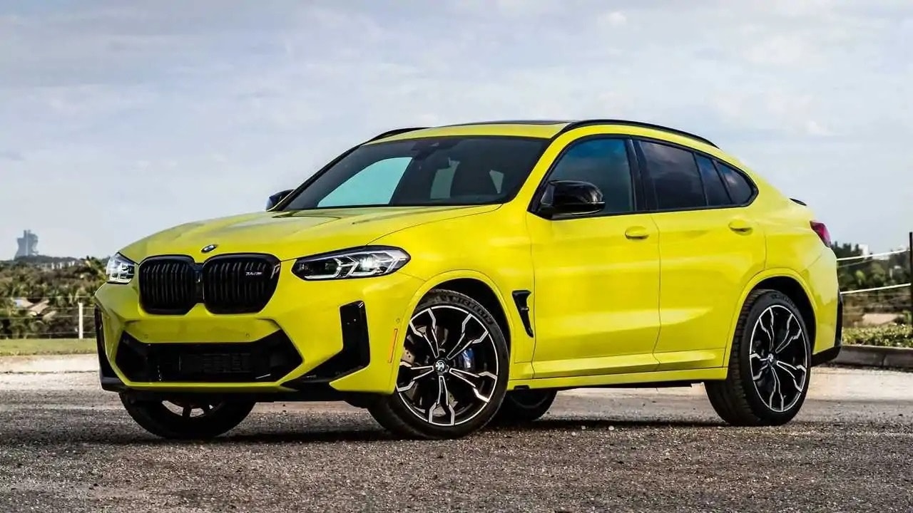 Chiếc BMW X4 M Competition màu xanh lá cây thể thao đậu trong một không gian hiện đại.