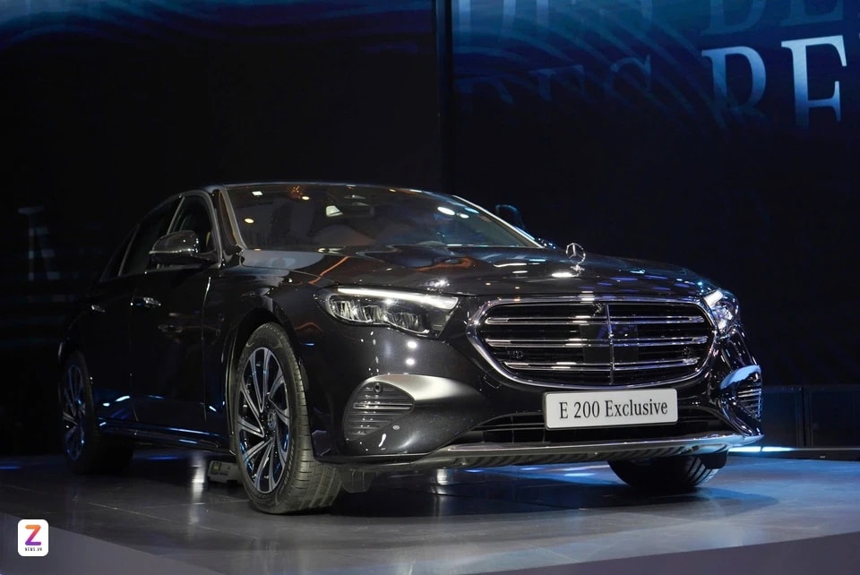 Phần đầu xe Mercedes-Benz E 200 Exclusive thế hệ mới với lưới tản nhiệt cổ điển và logo ngôi sao ba cánh trên nắp ca-pô.