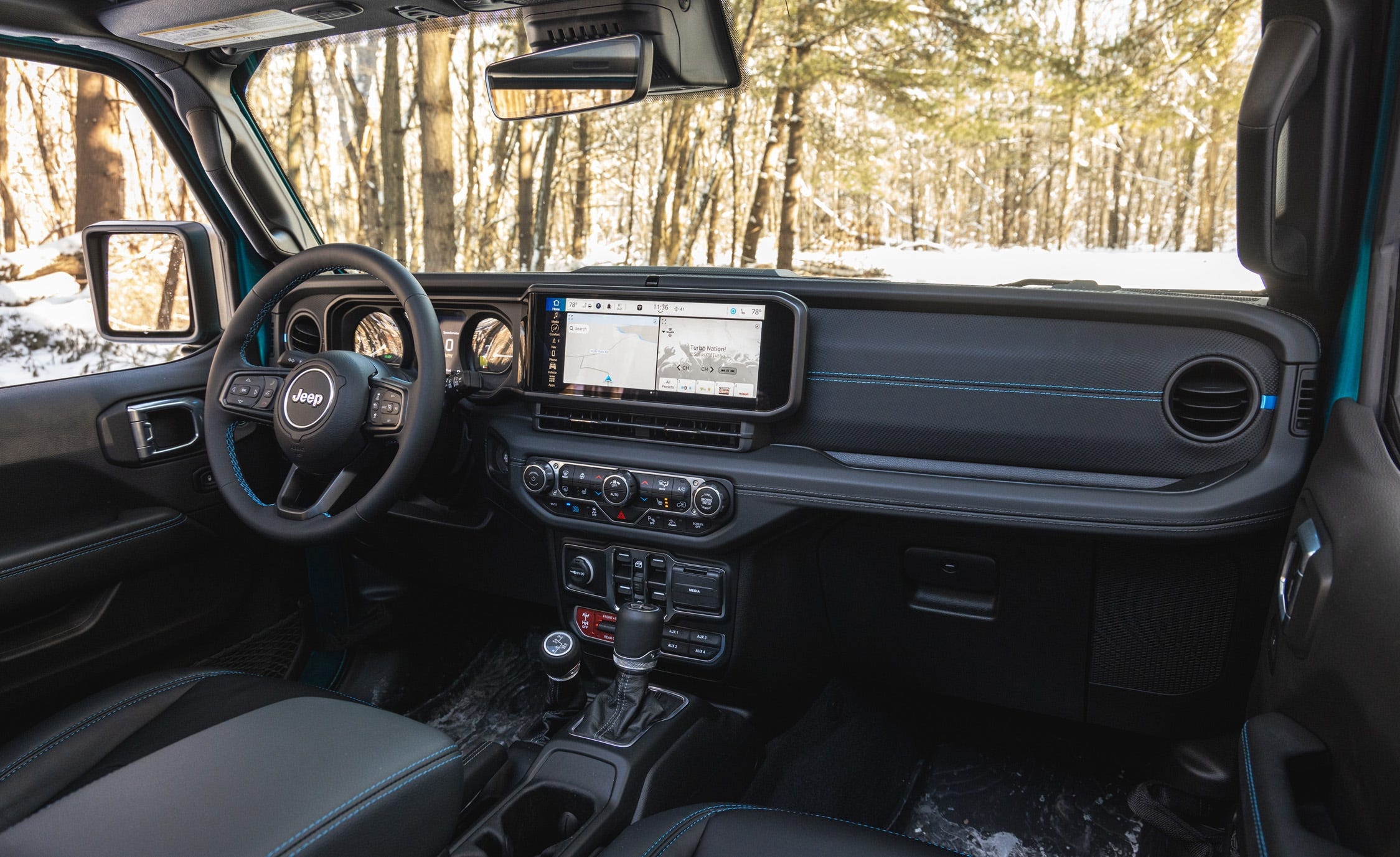 Khoang lái bên trái với màn hình bản đồ, cụm điều hòa và ghế màu đen