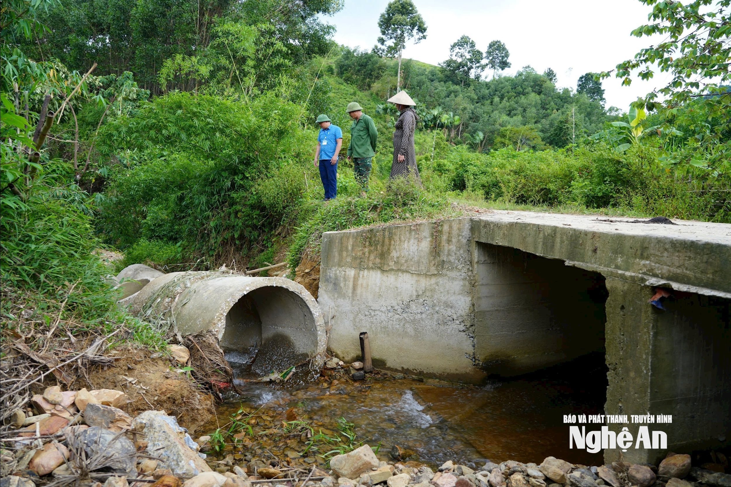 Cán bộ phòng Kinh tế hạ tầng xã Môn Sơn, khảo sát tình hình kênh mương ở bản Yên Hòa. Ảnh KL