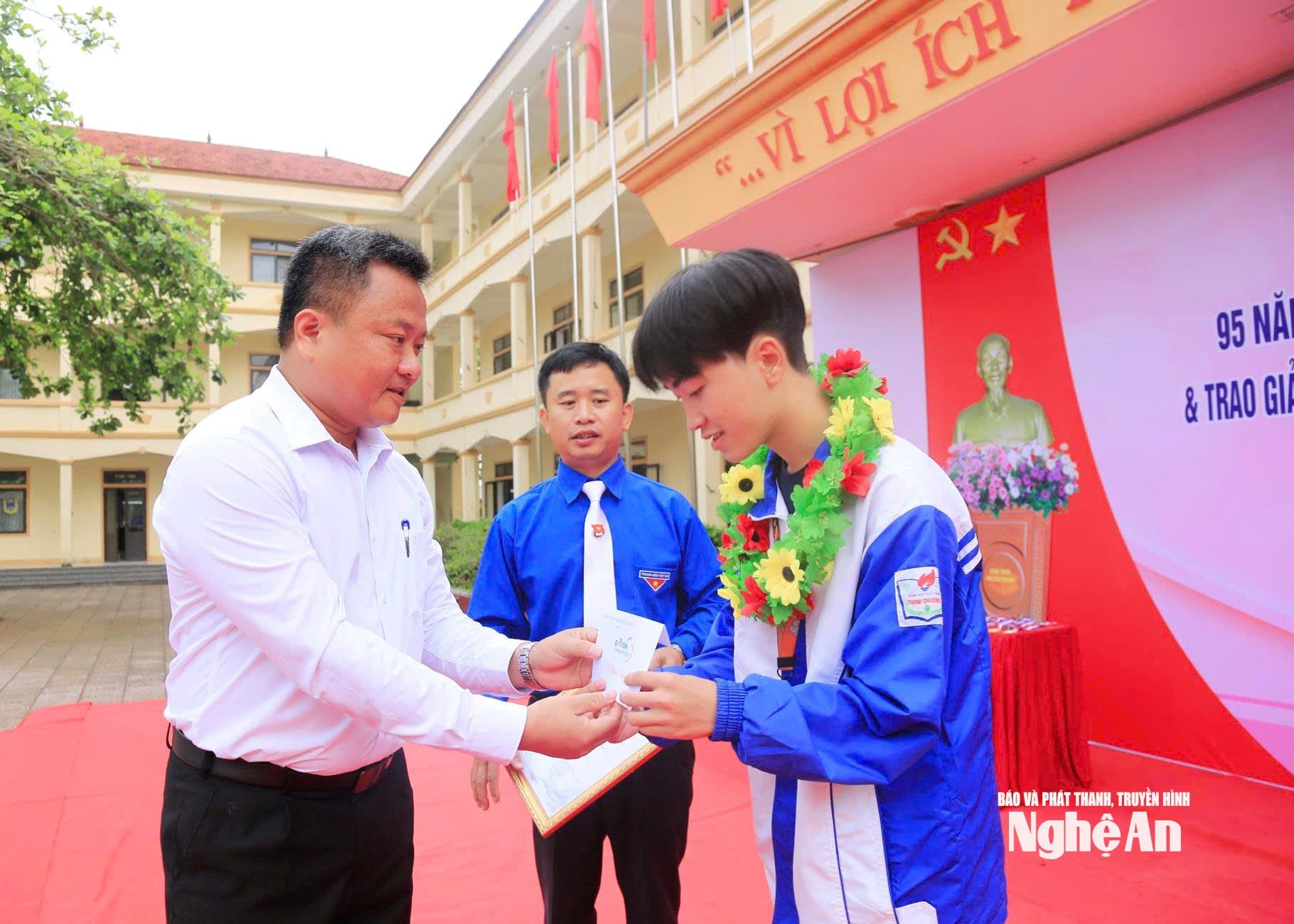 Thầy giáo Lê Văn Quyền khen thưởng cho các học sinh đạt giải tại hội thao của nhà trường.