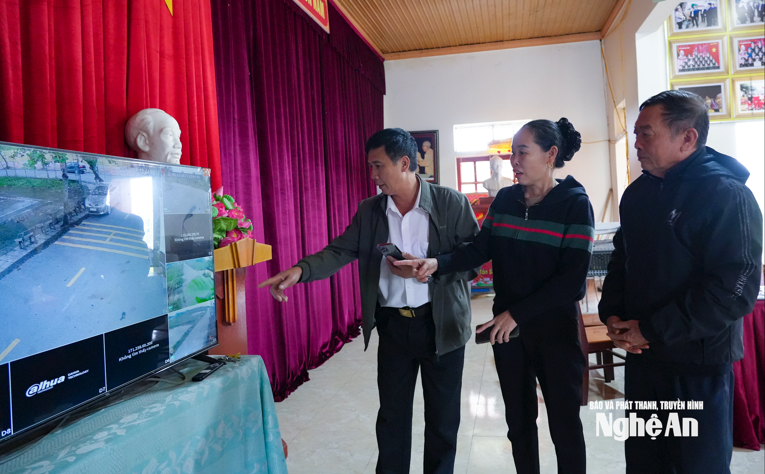 Ông Trần Ngọc Cảnh cùng cán bộ thôn xóm kiểm tra nàn hình thu phát từ các camera an ninh trong xóm. Ảnh GH