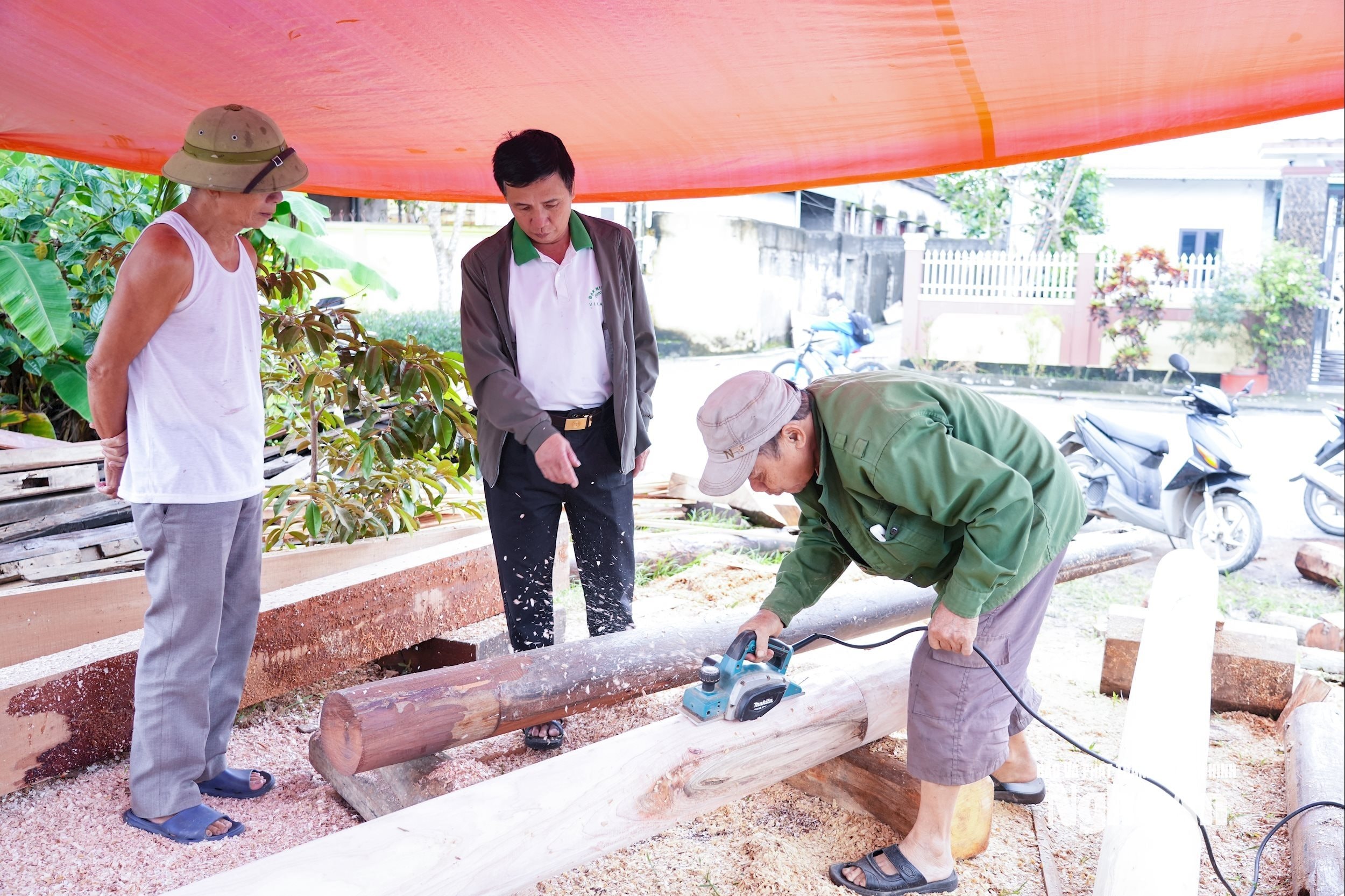 Ông Trần Ngọc Cảnh thăm một xưởng mộc trên địa bàn xóm. Ảnh Thanh Phúc