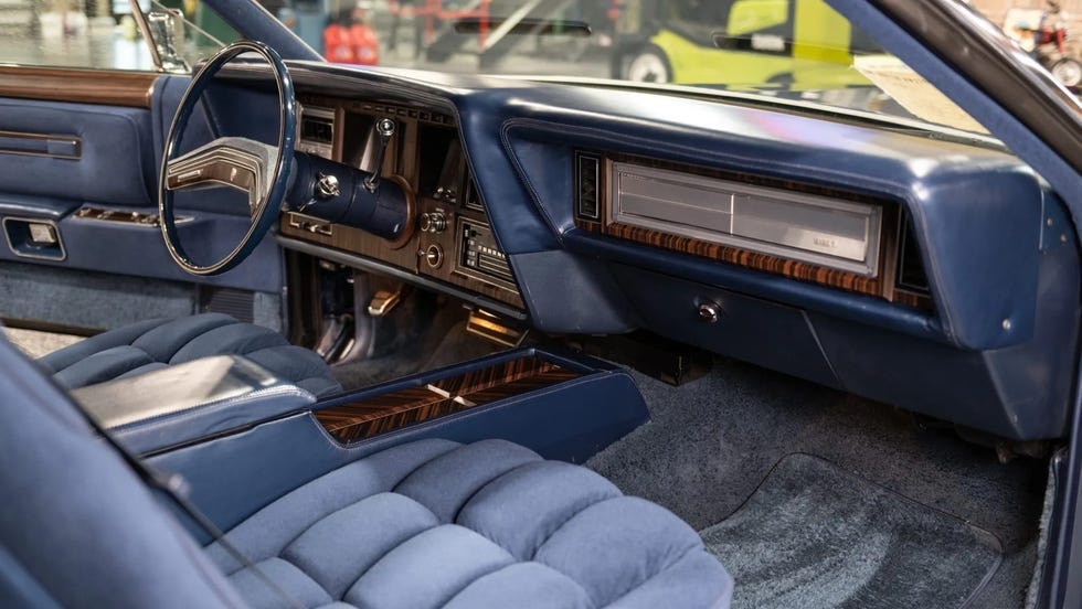 Khoang nội thất bên phụ với táp-lô xanh, vô-lăng và ghế bọc dày.