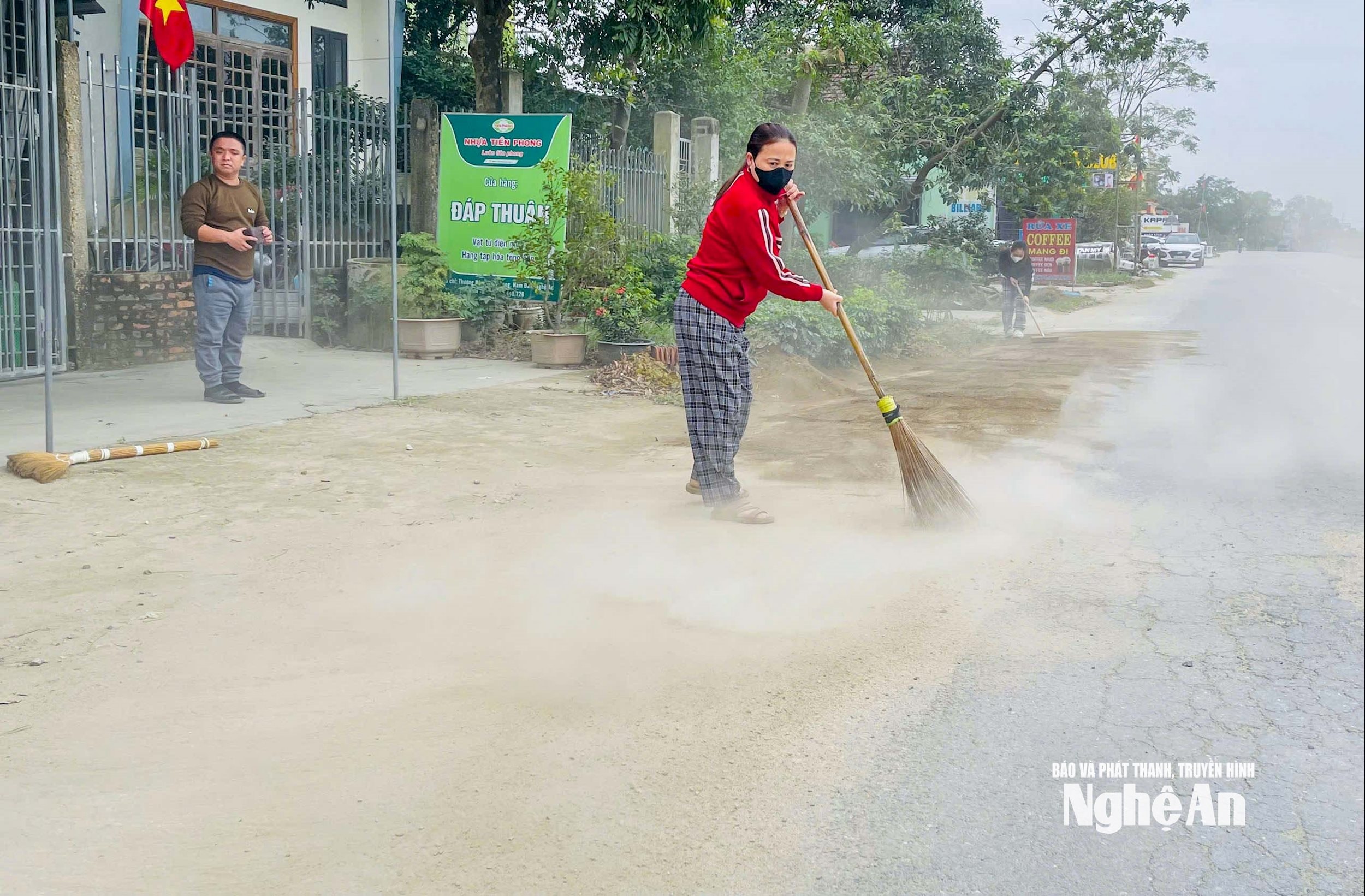 Människor i Thuong Nam-byn, Kim Lien-kommunen, städar upp sanden som är utspridd på vägen. Foto: Dinh Tuyen