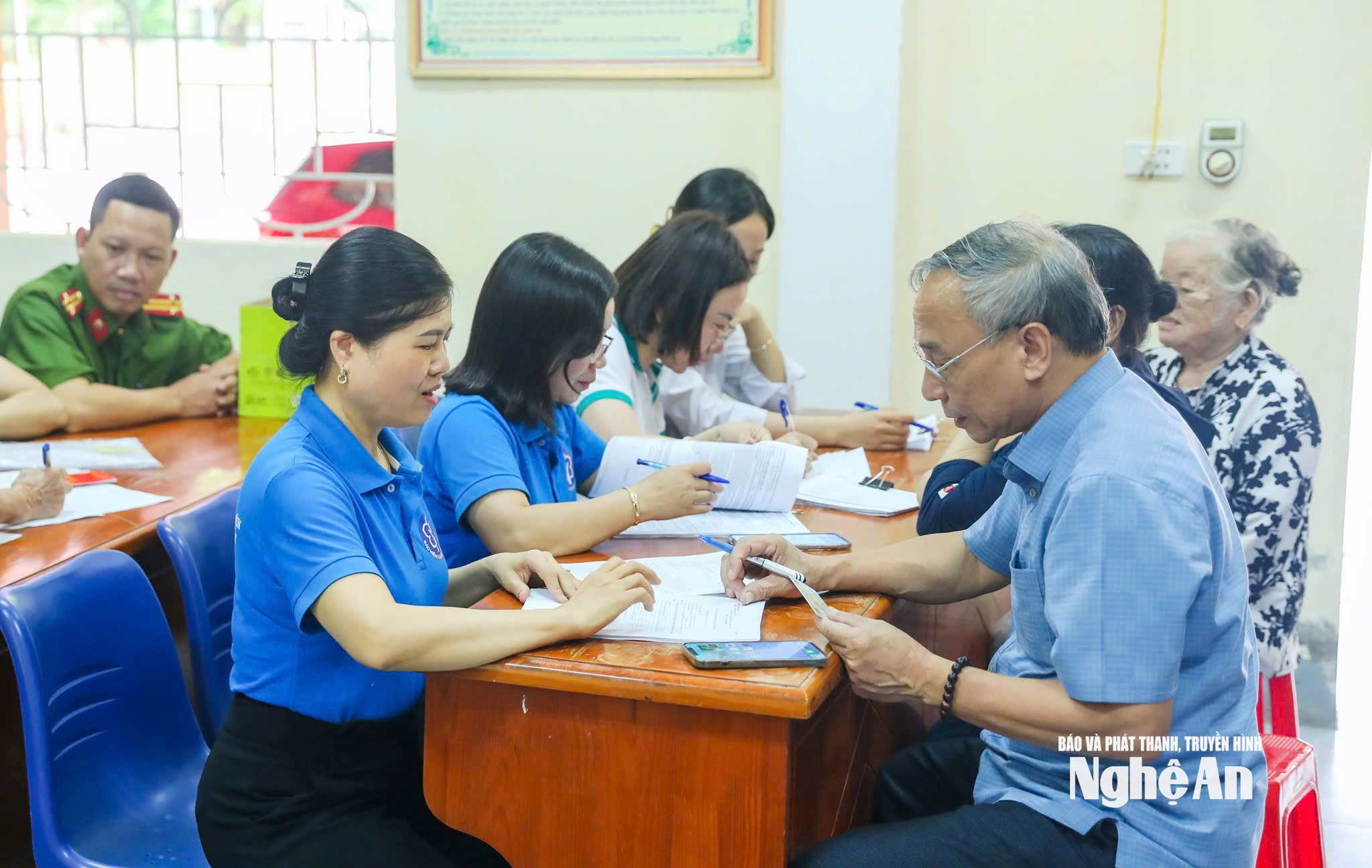 BHXH Nghệ An hỗ trợ người dân nhận lương hưu qua thẻ ATM. Ảnh Đức Anh