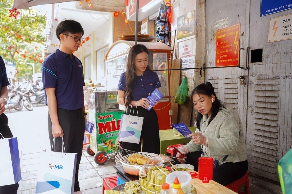 Nhân viên MB hướng dẫn tiểu thương chợ Hôm chuyển đổi số. Ảnh: MB