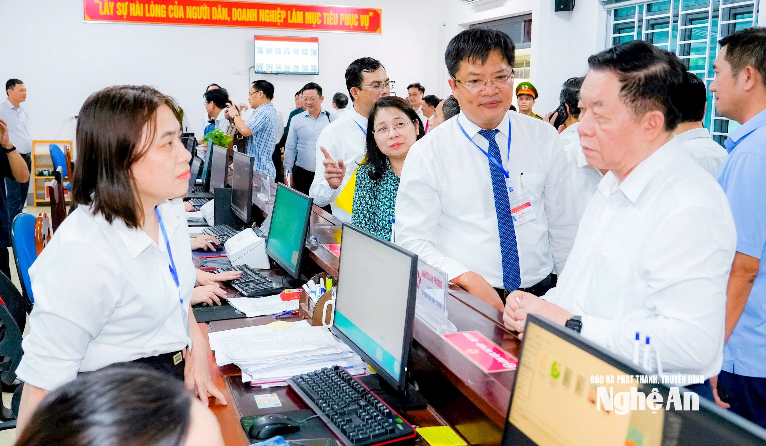 Trưởng ban Tuyên giáo và Dân vận Trung ương Nguyễn Trọng Nghĩa trao đổi với người dân đến làm thủ tục hành chính tại Trung tâm Phục vụ hành chính công phường Cửa Lò. Ảnh: Phạm Bằng